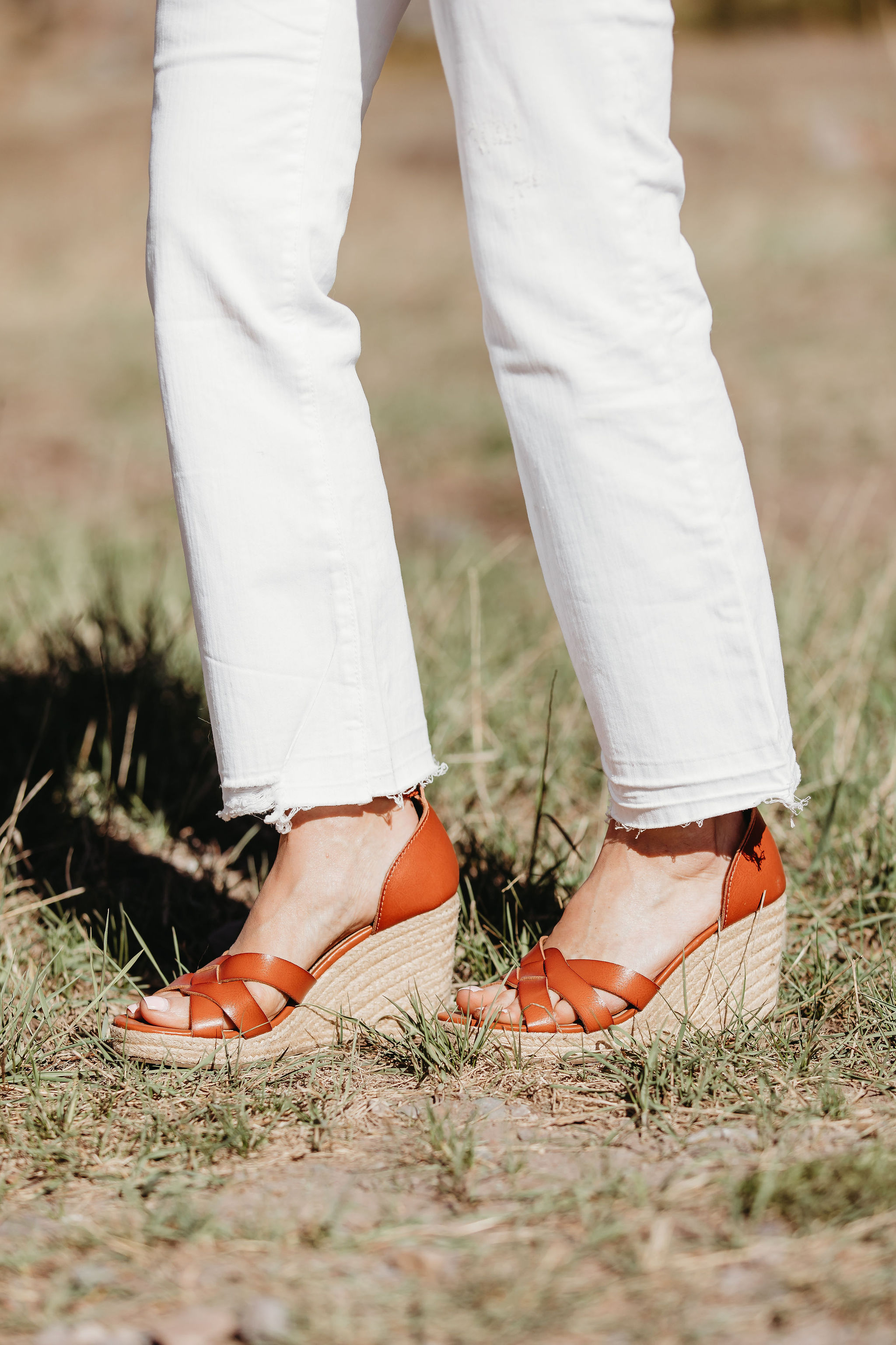 Affordable Summer Tops, Fashion blogger Erin Busbee of BusbeeStyle.com wearing a black crocheted flutter sleeve top with white cropped kick flare jeans, straw circle bag, and brown espadrille wedges by Scoop from Walmart in Telluride, Colorado