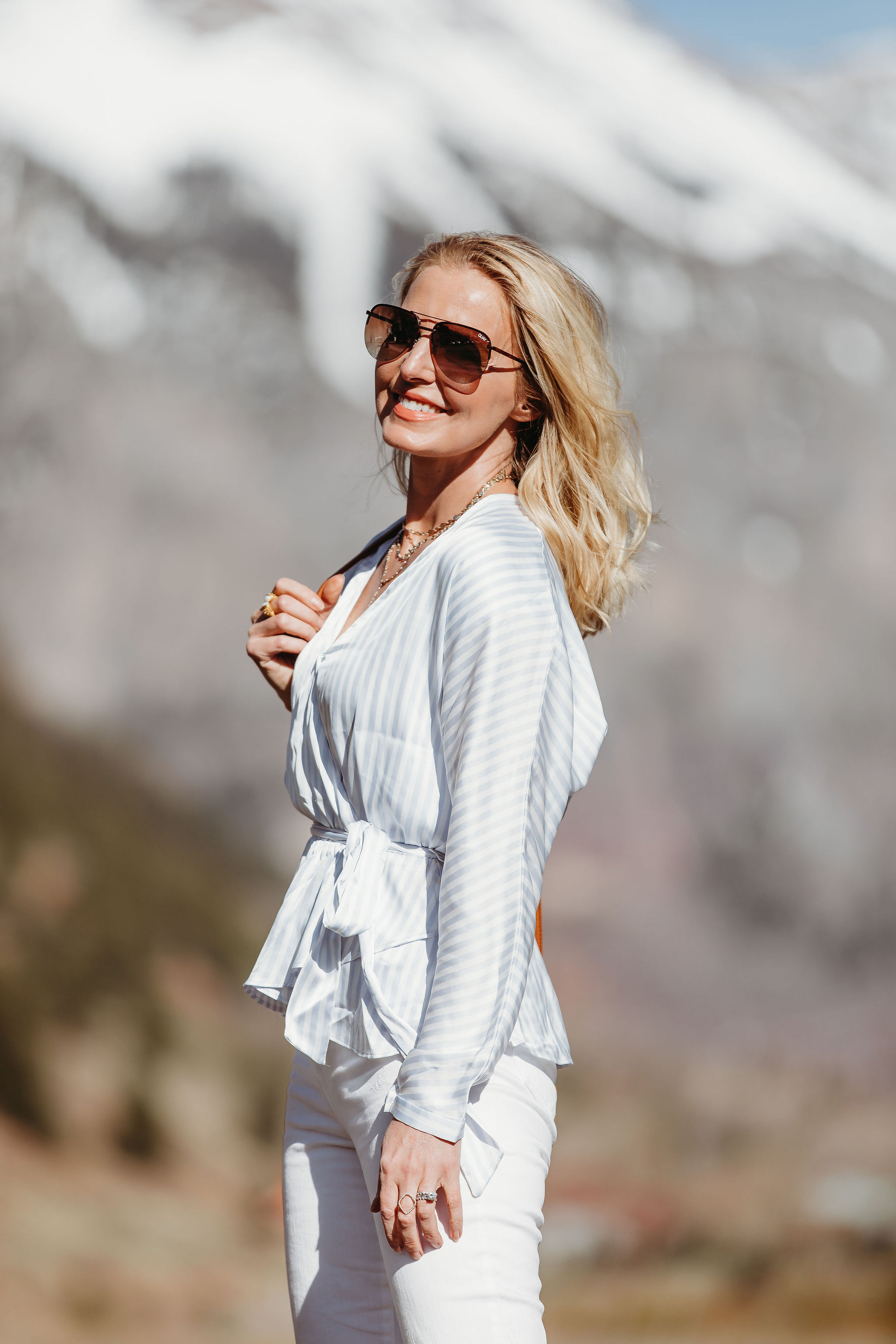 Affordable Summer Tops, Fashion blogger Erin Busbee of BusbeeStyle.com wearing a blue and white striped faux wrap top with white cropped kick flare jeans, straw circle bag, and brown espadrille wedges by Scoop from Walmart in Telluride, Colorado