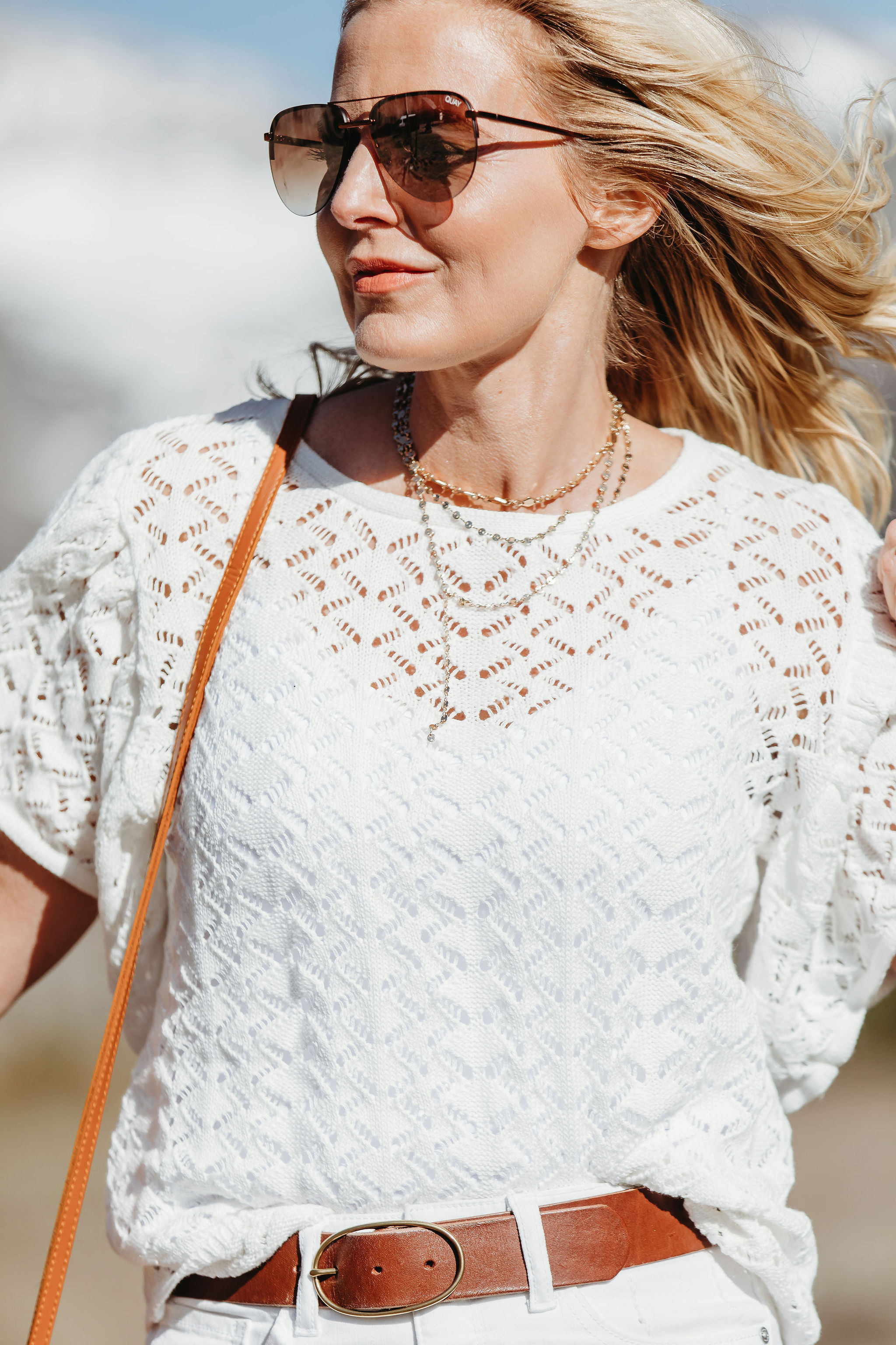 Affordable Summer Tops, Fashion blogger Erin Busbee of BusbeeStyle.com wearing a white knit top with white cropped kick flare jeans, straw circle bag, and brown espadrille wedges by Scoop from Walmart in Telluride, Colorado