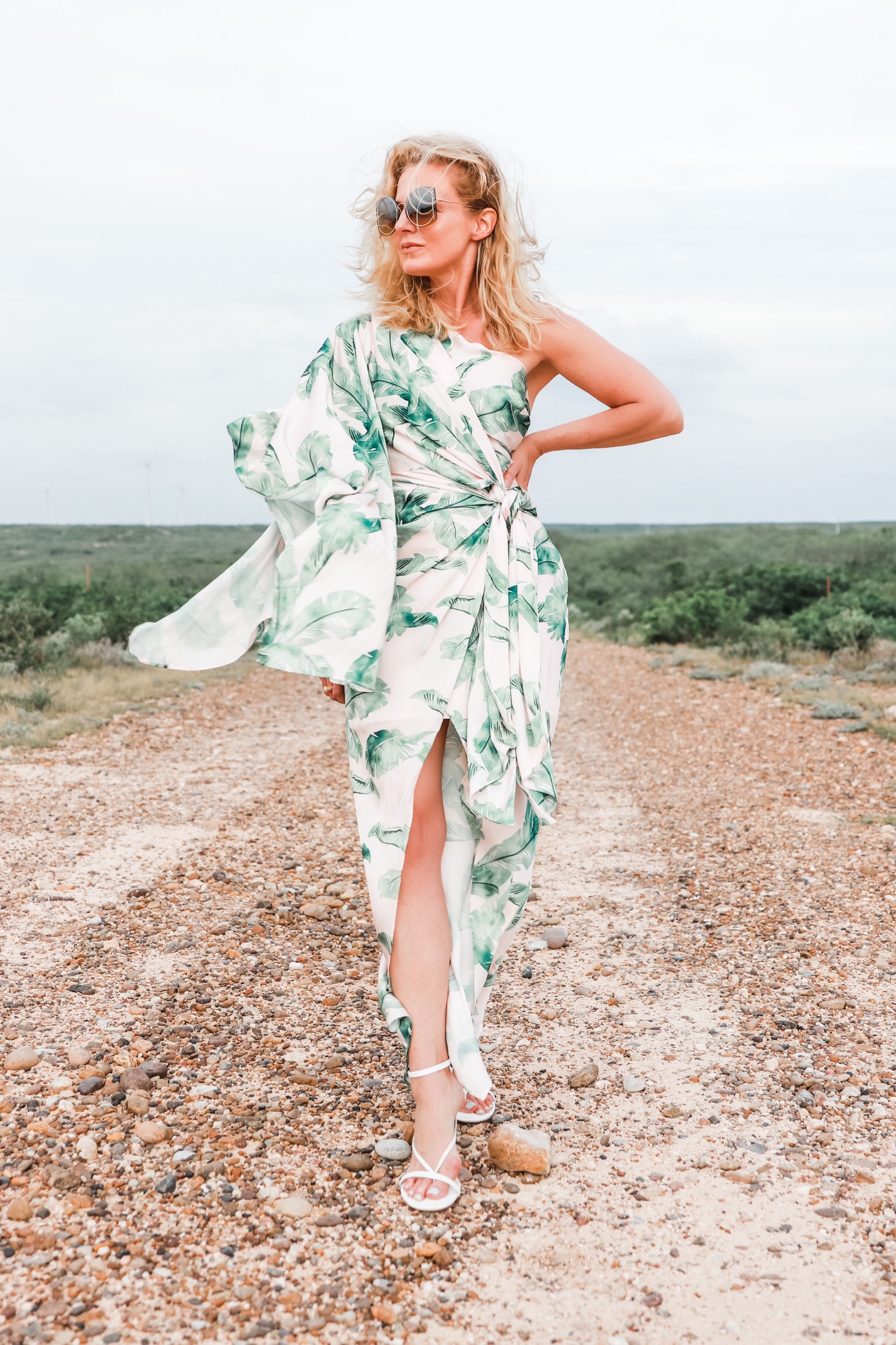 Palm Print Dress, fashion blogger Erin Busbee of Busbee Style wearing a pink and green palm print dress by Significant other with white sandals on a ranch in south Texas