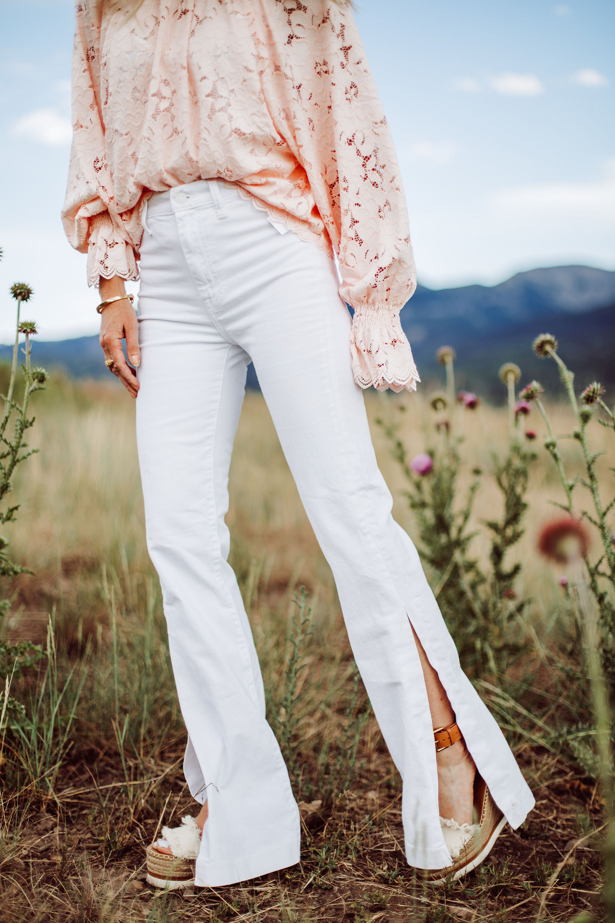 White Jeans for women Over 40, Fashion blogger Busbee Style wearing white 7 For All Mankind split hem jeans, See by Chloe espadrille wedges, pink lace long sleeve Free People top in Telluride, Colorado