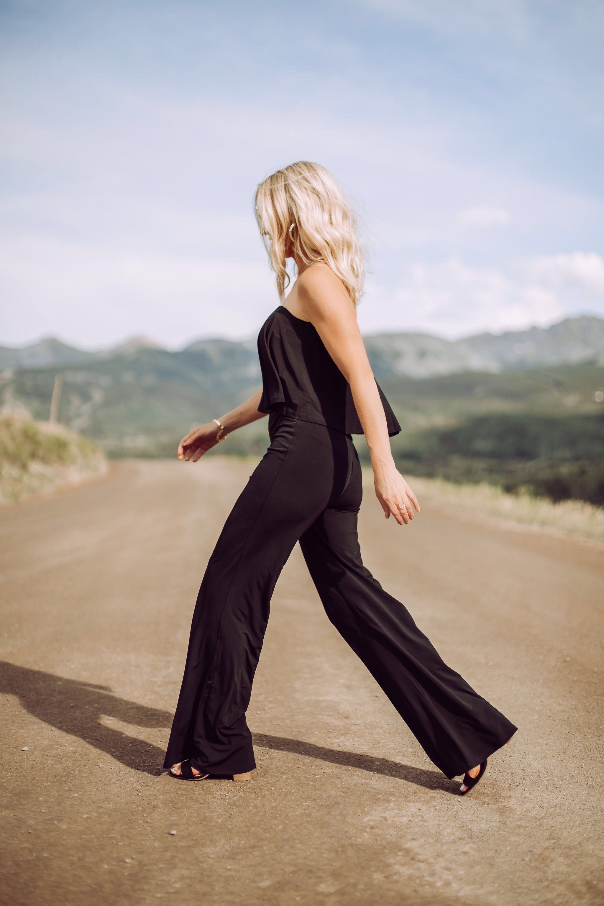 Jumpsuits Over 40, Fashion Blogger Erin Busbee of Busbee Style wearing a black flared jumpsuit by Scoop and black strappy block heel sandals by Scoop from Walmart walking in Telluride, Colorado