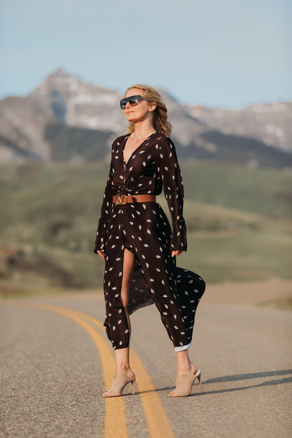 Black dress, fashion blogger Erin Busbee of Busbee Style wearing a black printed dress by Rotate with a Valentino belt, nude Vince Camuto mules, and flat top sunglasses in Telluride, Colorado