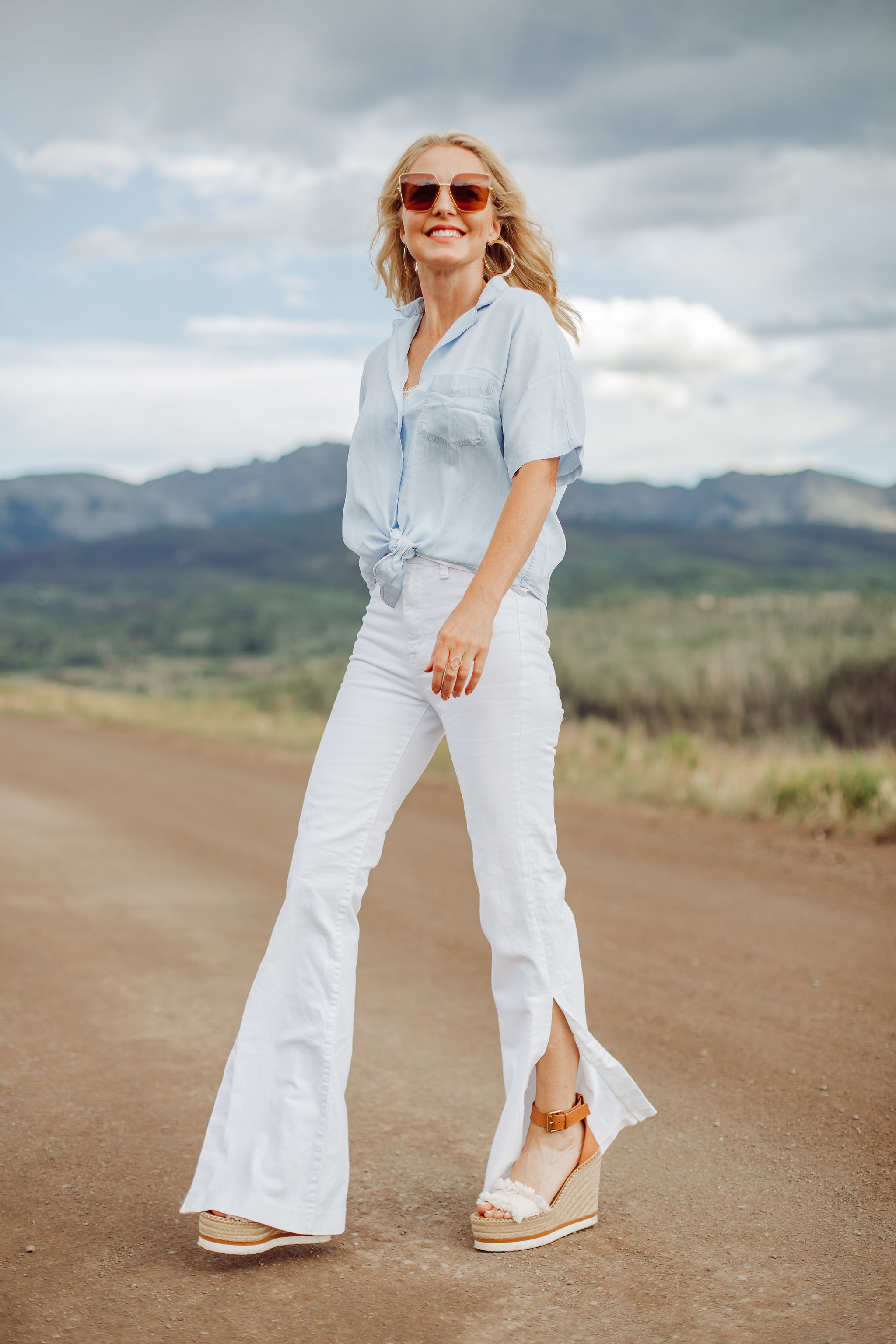 Blouses That Cover Arms, Fashion blogger Erin Busbee of Busbee Style wearing a blue tie-front button down shirt by Rails with high waisted white slit hem jeans by 7 For All Mankind and See by Chloe wedges and Saint Laurent sunglasses in Telluride, Colorado