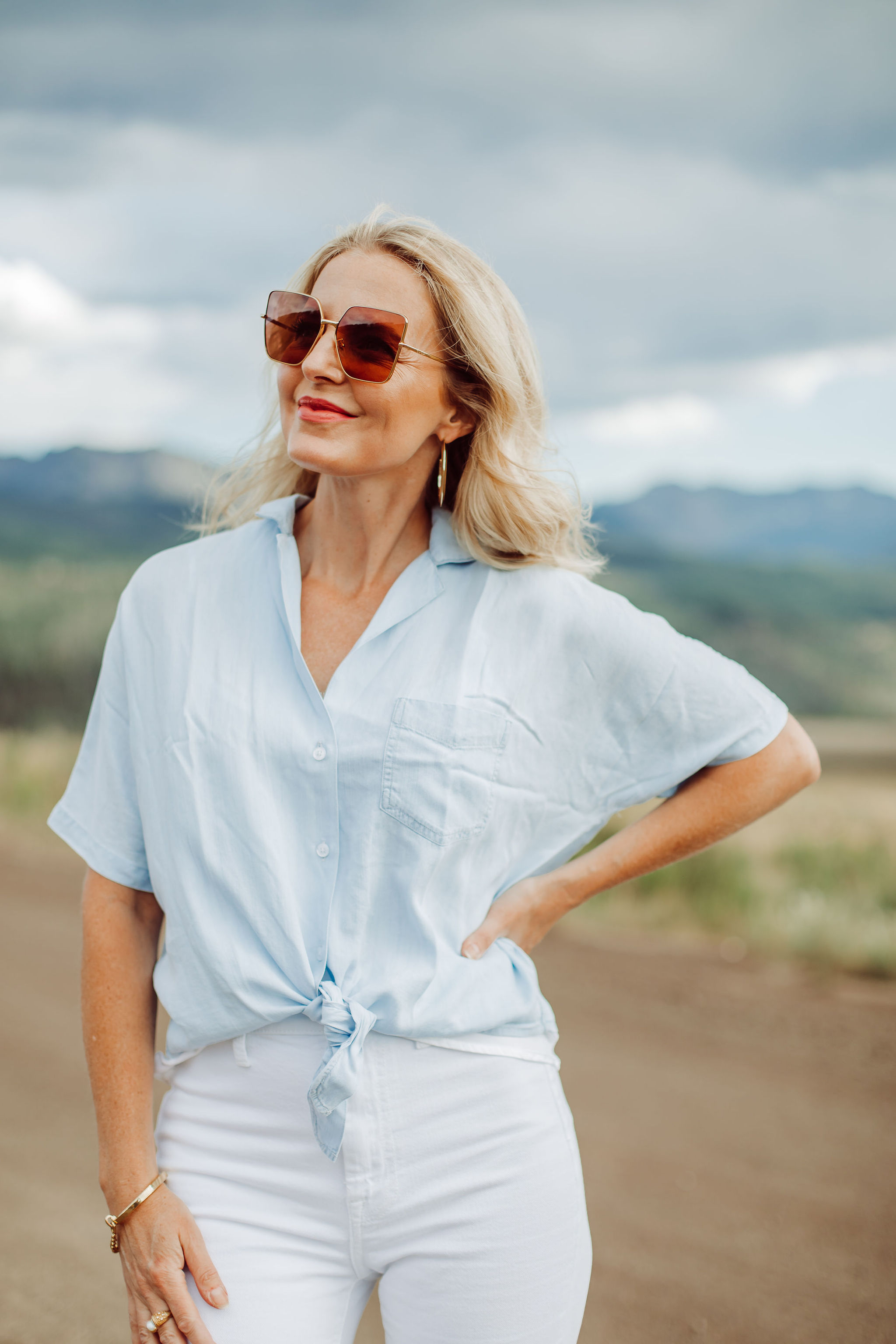 Blouses That Cover Arms, Fashion blogger Erin Busbee of Busbee Style wearing a blue tie-front button down shirt by Rails with high waisted white slit hem jeans by 7 For All Mankind and See by Chloe wedges and Saint Laurent sunglasses in Telluride, Colorado