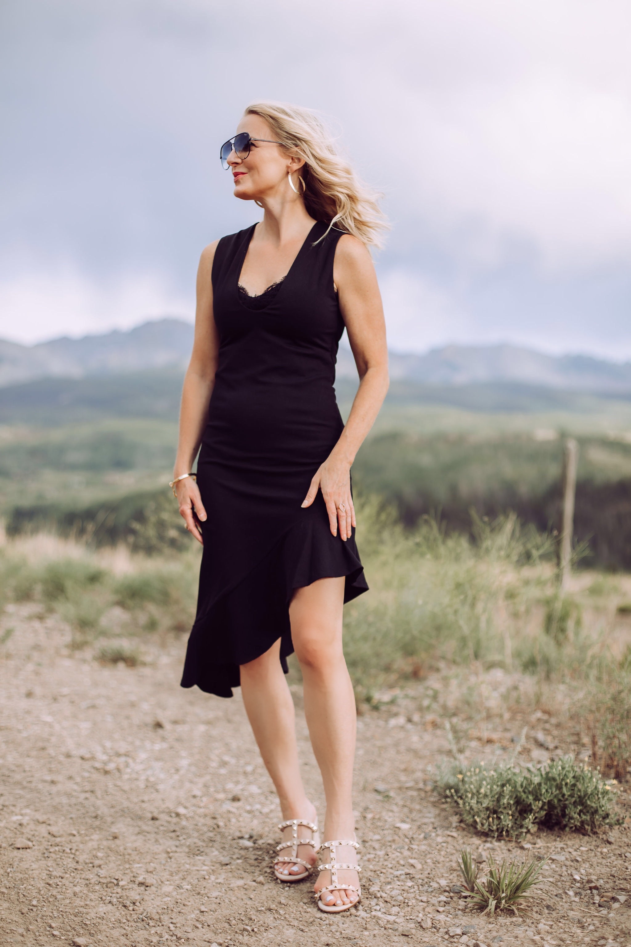 Date Night Outfit Over 40, Fahsion blogger Erin Busbee of Busbee Style wearing a black asymmetrical Susana Monaco dress with lace cami, Valentino Sandals, and QUAY aviator sunglasses in Telluride, Colorado