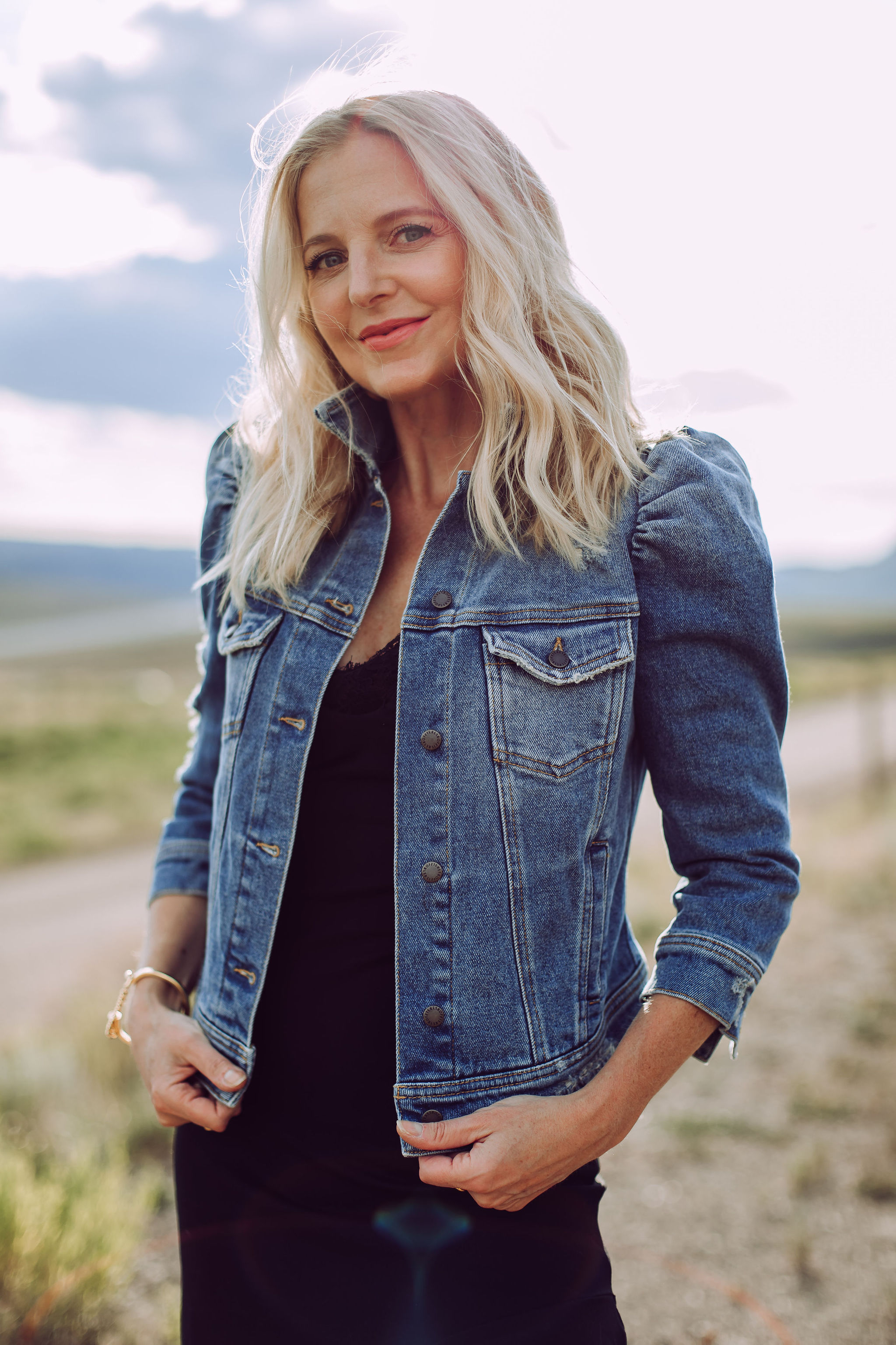 Day To Date Night Outfits, Fashion blogger Erin Busbee of Busbee Style wearing a black susana monaco dress with golden goose sneakers, retrofete denim puff sleeve jacket and aviator sunglasses in Telluride, Colorado