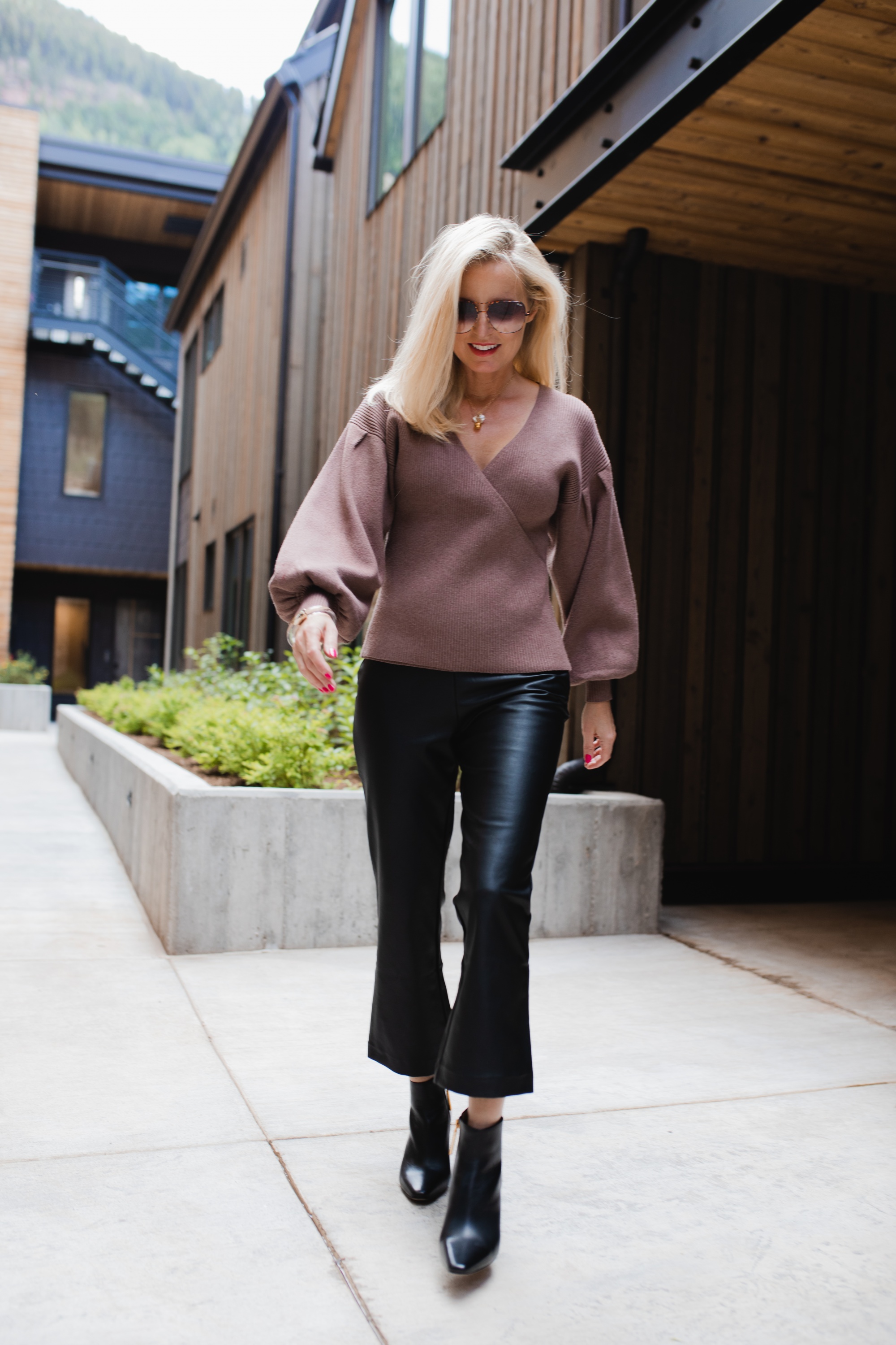 How to Wear Leather Pants, Fashion blogger Erin Busbee of Busbee Style wearing black faux leather pants by Halogen with a brown All In Favor bishop sleeve sweater, black Louise et Cie booties, and brown QUAY sunglasses in Telluride, Colorado