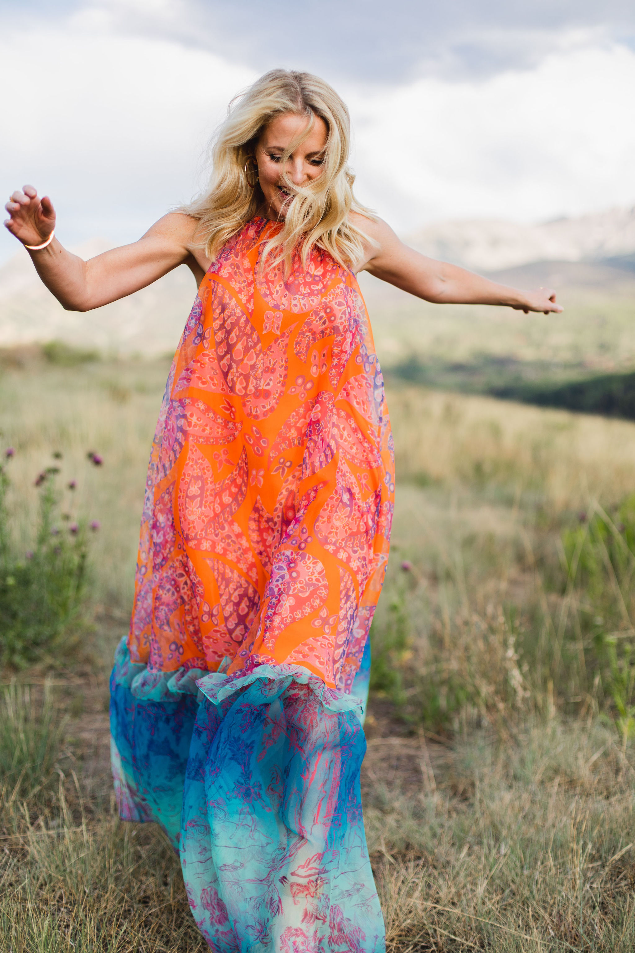 How To Manifest Anything, Fashion blogger Erin Busbee of Busbee Style wearing an orange and blue Staud Ina dress with white sunglasses walking around in Telluride, Colorado