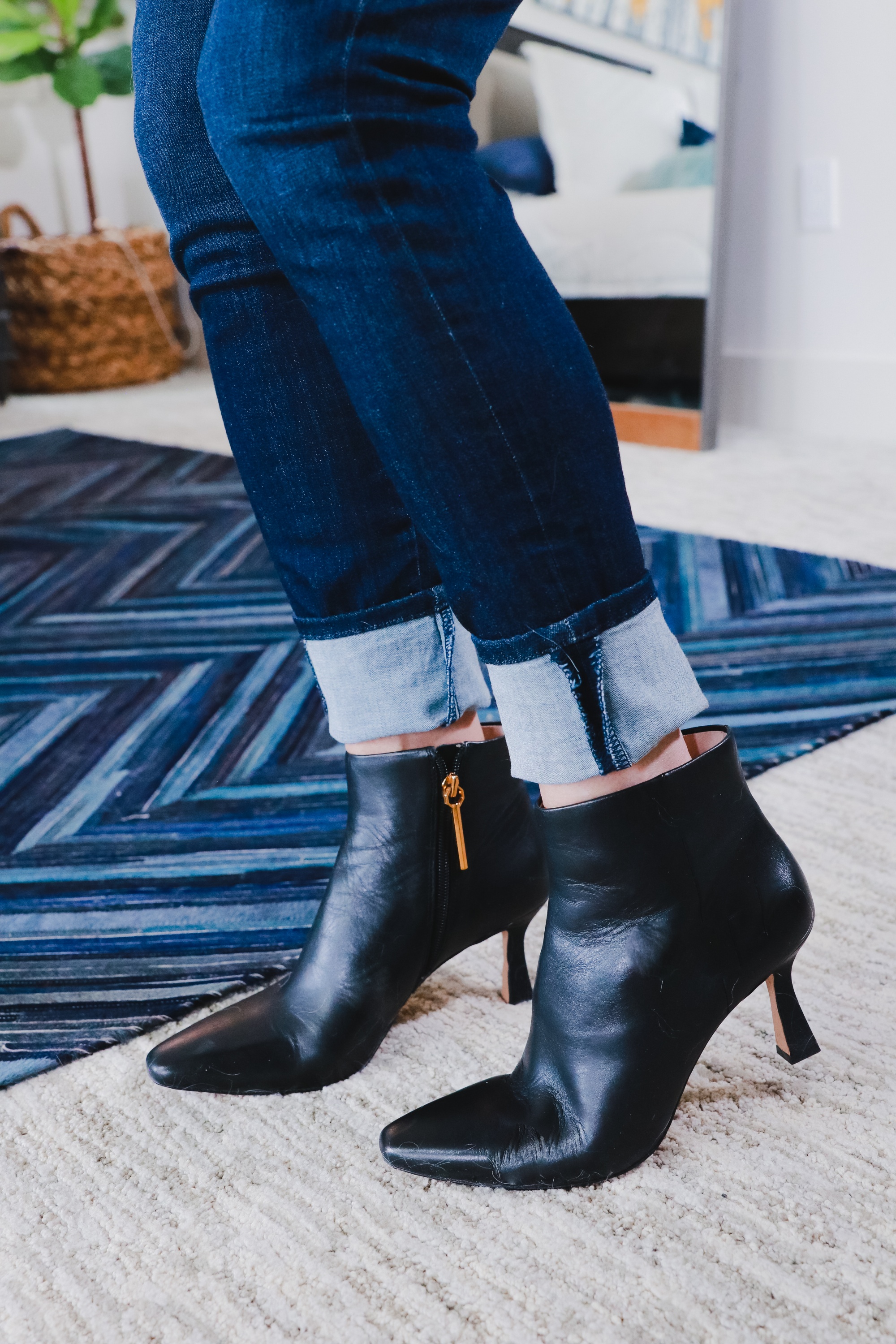 how to cuff skinny or straight leg jeans to wear with ankle booties, fashion blogger wearing black ankle boots with straight leg blue jeans