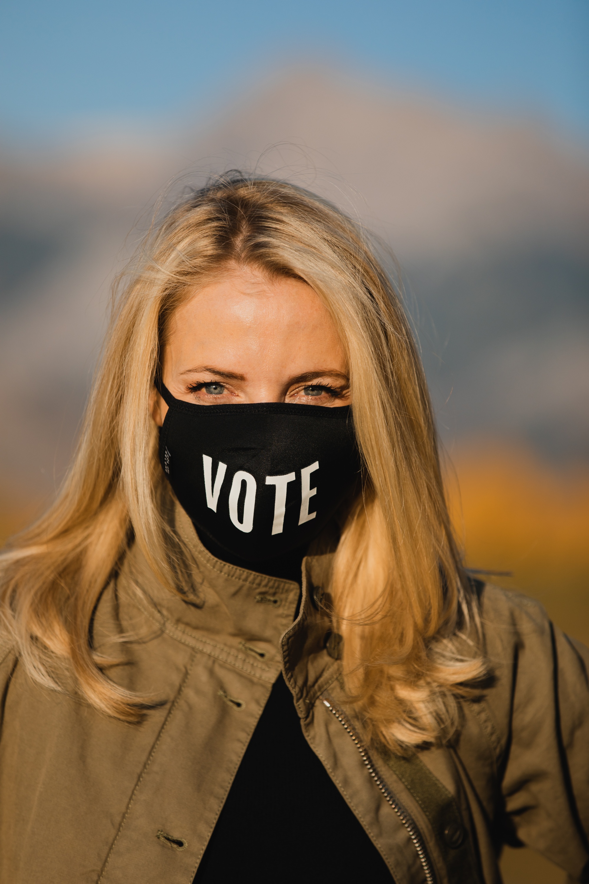 How To Wear A Cargo Jacket, Erin Busbee of Busbee Style wearing a green cargo jacket by rag & bone, black turtleneck puff sleeve cashmere sweater by Aqua, gray wash Nico slim fit jeans by Agolde, QUAY sunglasses, Vote mask, and Alexander Wang cutout booties from Bloomingdale's in Telluride, Colorado