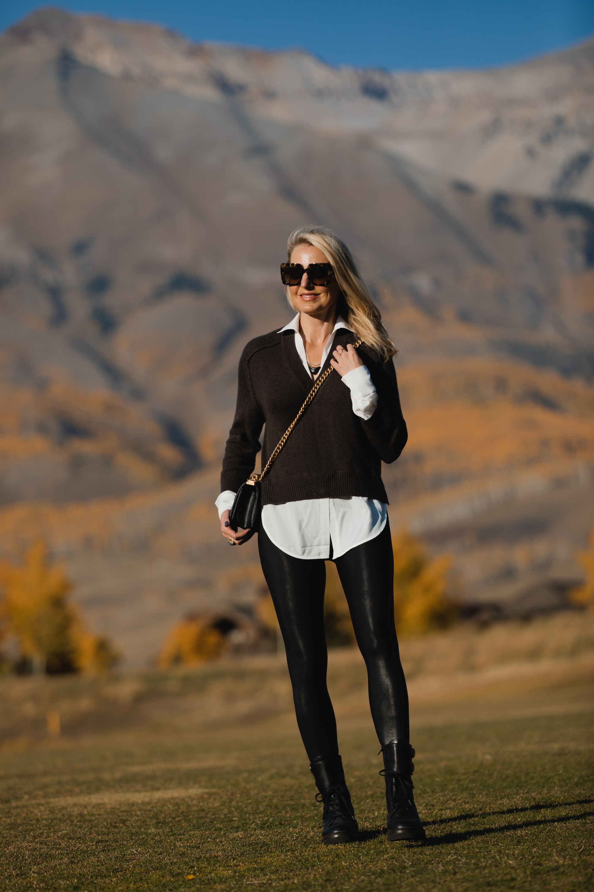 Layered Sweater, Erin Busbee of Busbee Style wearing a brown layered sweater by Brochu Walker, Spanx faux leather leggings, See by Chloe combat boots, and black Chanel boy bag in Telluride, Colorado