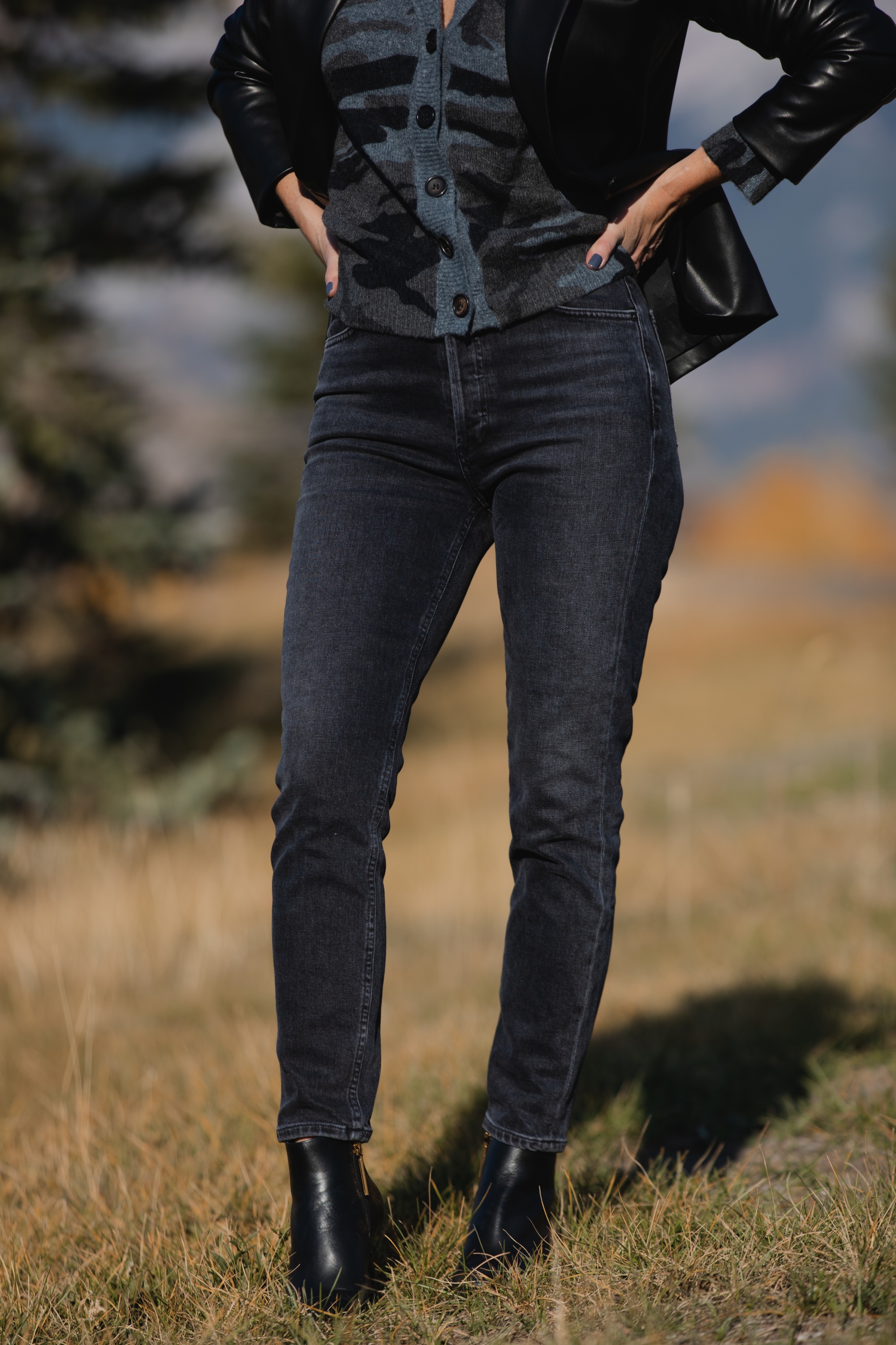 Favorite Fall Jackets, Erin Busbee of Busbee Style holding a black faux leather blazer by Theory and wearing dark gray wash Agolde Nico jeans, black Louise et Cie booties, and Rails camo cardigan sweater in Telluride, Colorado