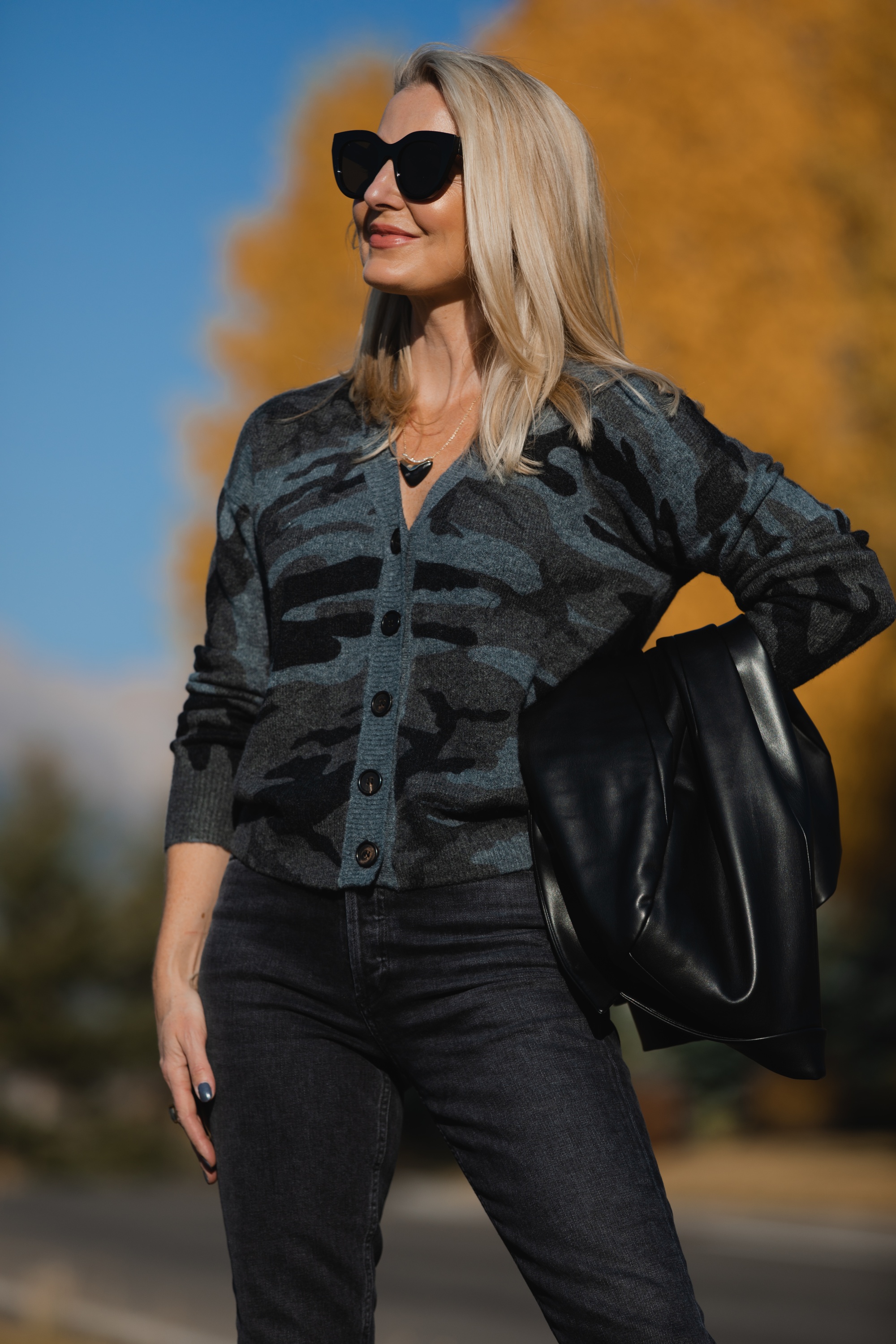 Favorite Fall Jackets, Erin Busbee of Busbee Style holding a black faux leather blazer by Theory and wearing dark gray wash Agolde Nico jeans, black Louise et Cie booties, and Rails camo cardigan sweater in Telluride, Colorado
