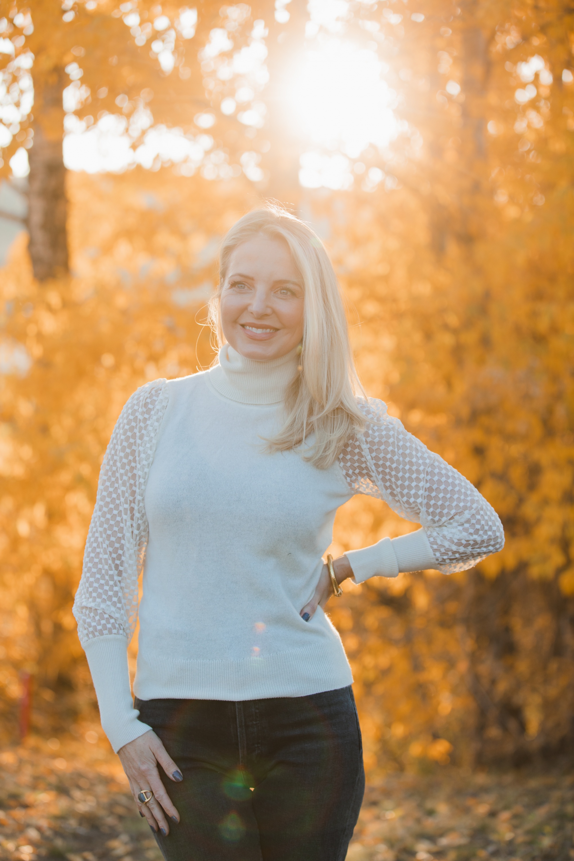 Fall sweater, Erin Busbee of Busbee Style wearing an ivory Aqua cashmere turtleneck sweater with mesh sleeves with dark gray jeans by Agolde in Telluride, Colorado