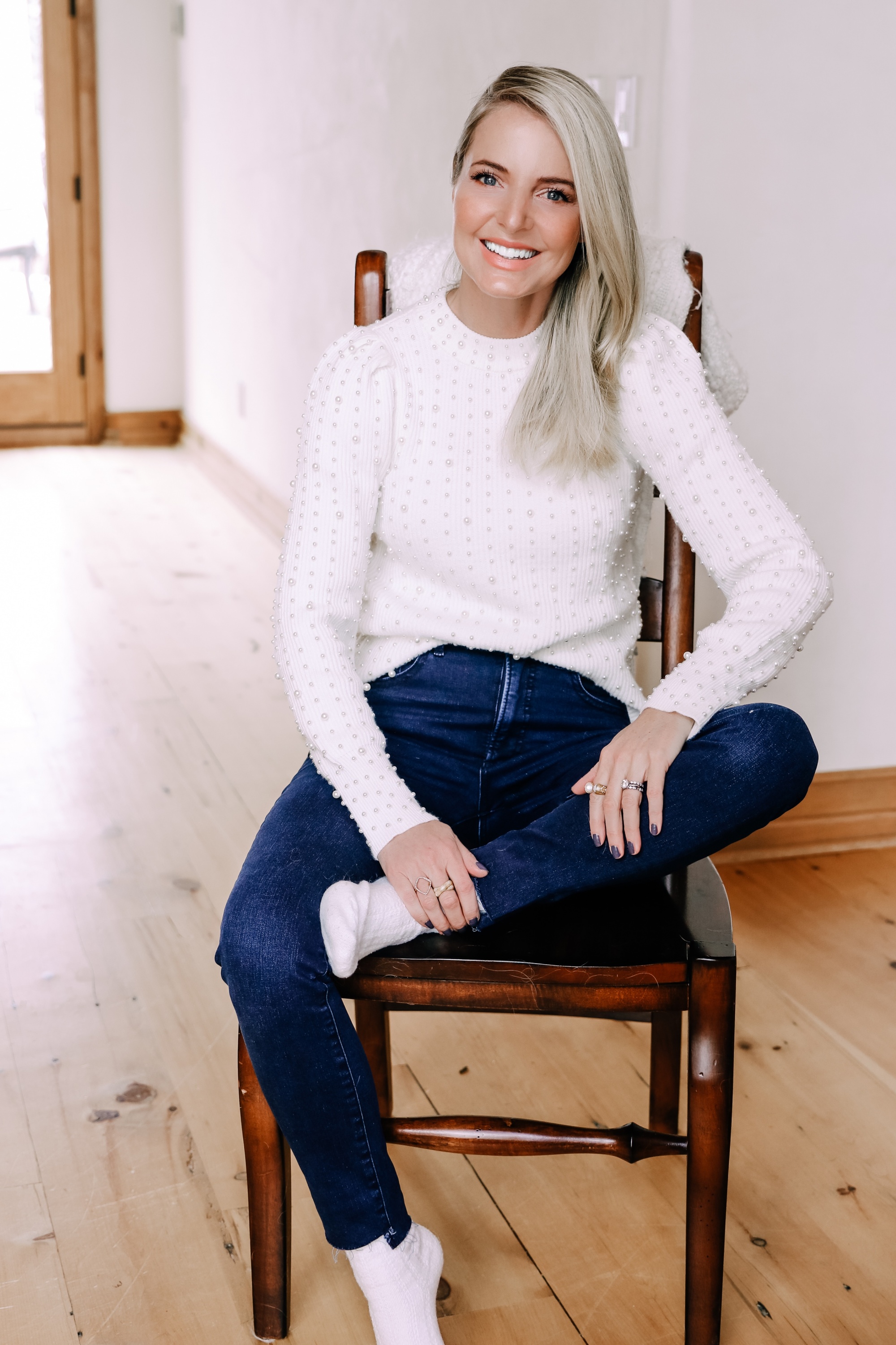 Black Friday Doorbuster, Erin Busbee of Busbee Style wearing a pearl embellished white sweater, raw step hem jeans, and cozy socks from Express in Telluride, Colorado