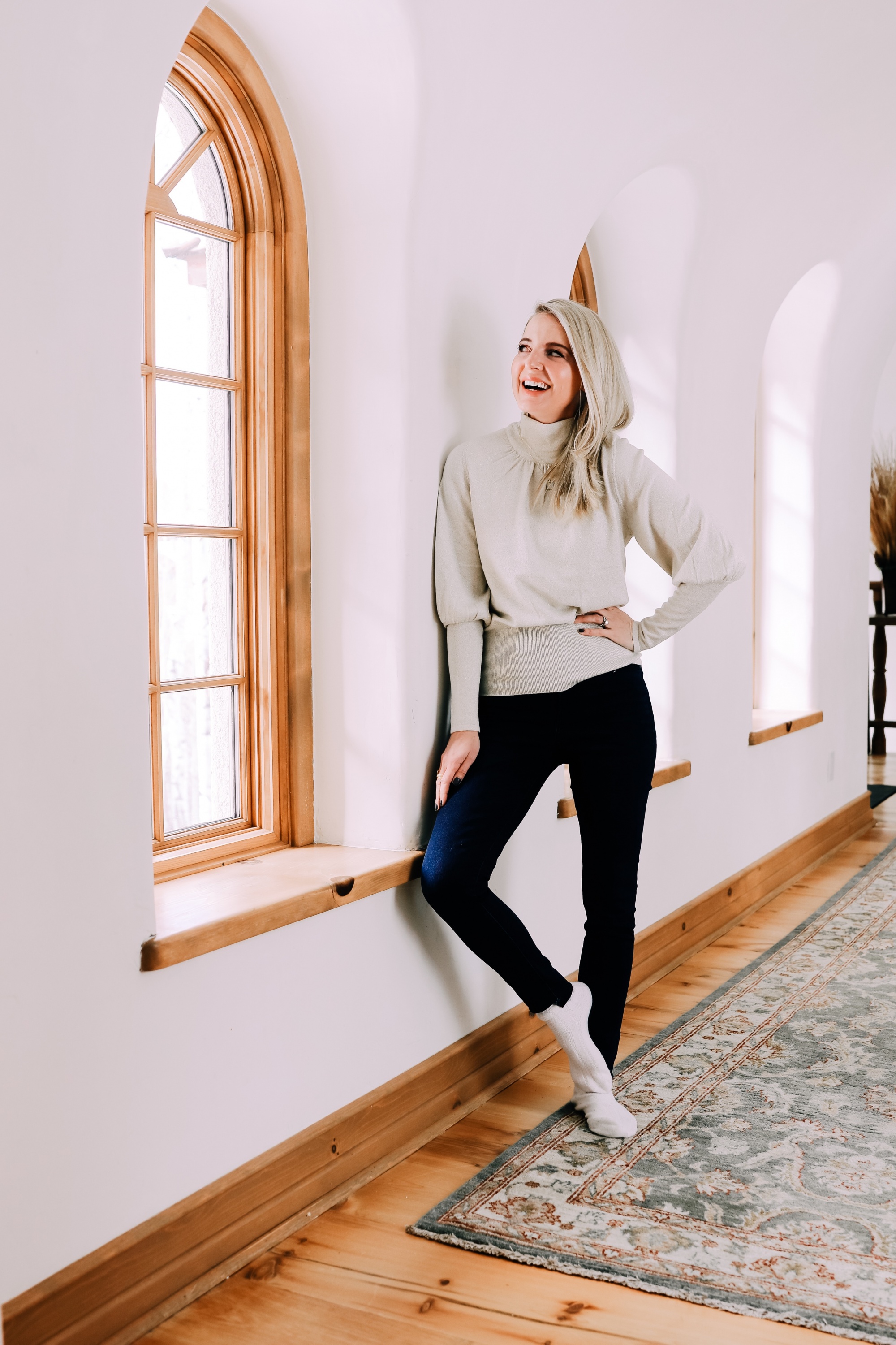 Black Friday Doorbuster, Erin Busbee of Busbee Style wearing a metallic blouson sleeve turtleneck sweater, raw step hem jeans, pave layered dog tag necklace, and cozy socks from Express in Telluride, Colorado