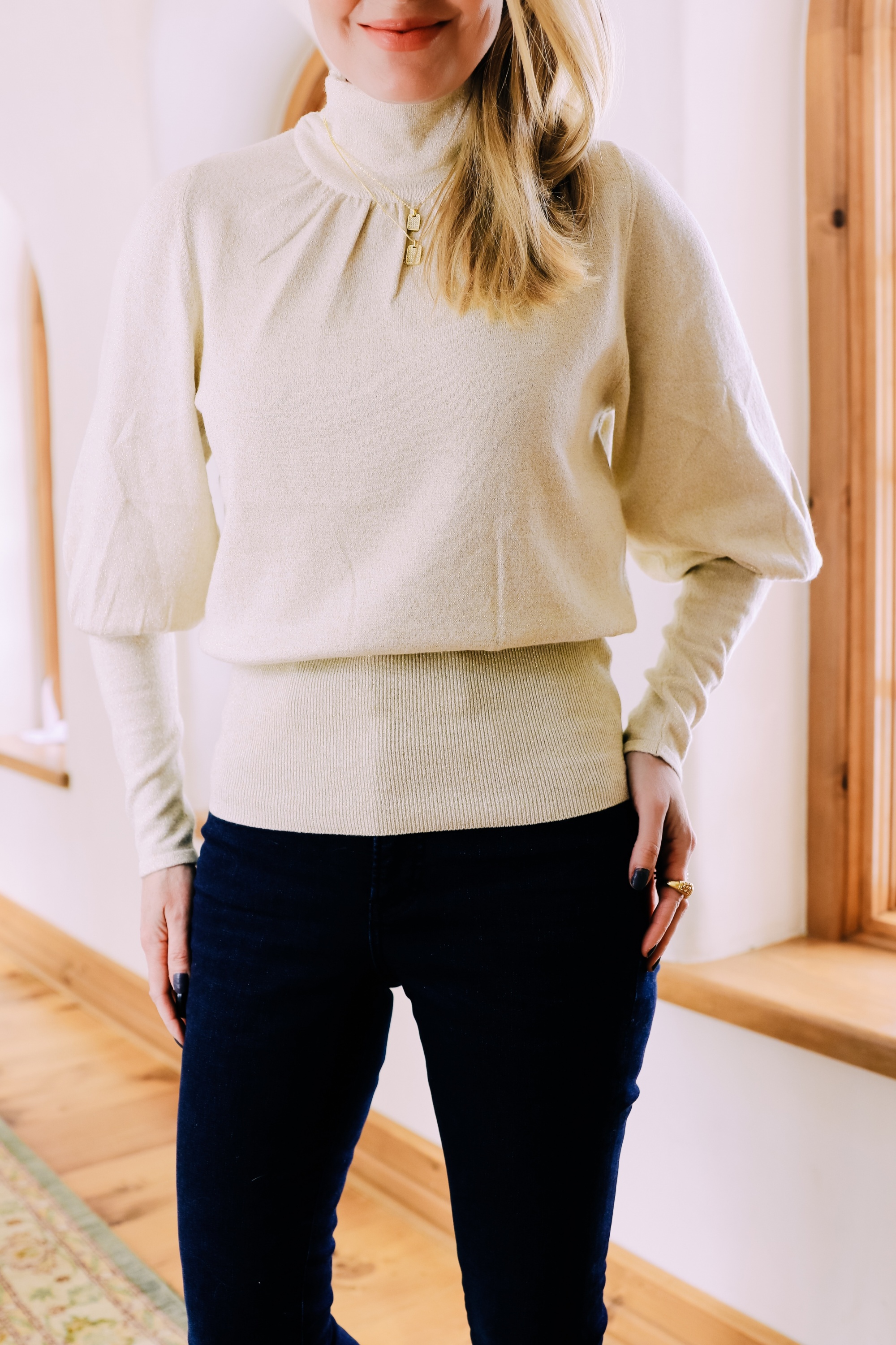 Black Friday Doorbuster, Erin Busbee of Busbee Style wearing a metallic blouson sleeve turtleneck sweater, raw step hem jeans, pave layered dog tag necklace, and cozy socks from Express in Telluride, Colorado