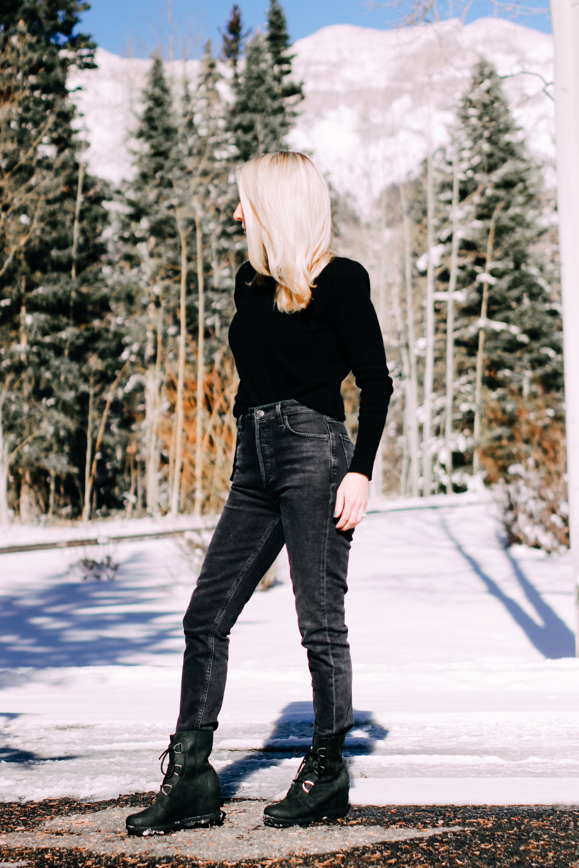 Thoughtful Gifts, Erin Busbee of Busbee Style wearing a black puff sleeve cashmere sweater by AQUA, gray wash Agolde jeans, black Sorel boots, and a diamond star necklace by Marc & Marcella from Bloomingdale's in Telluride, Colorado