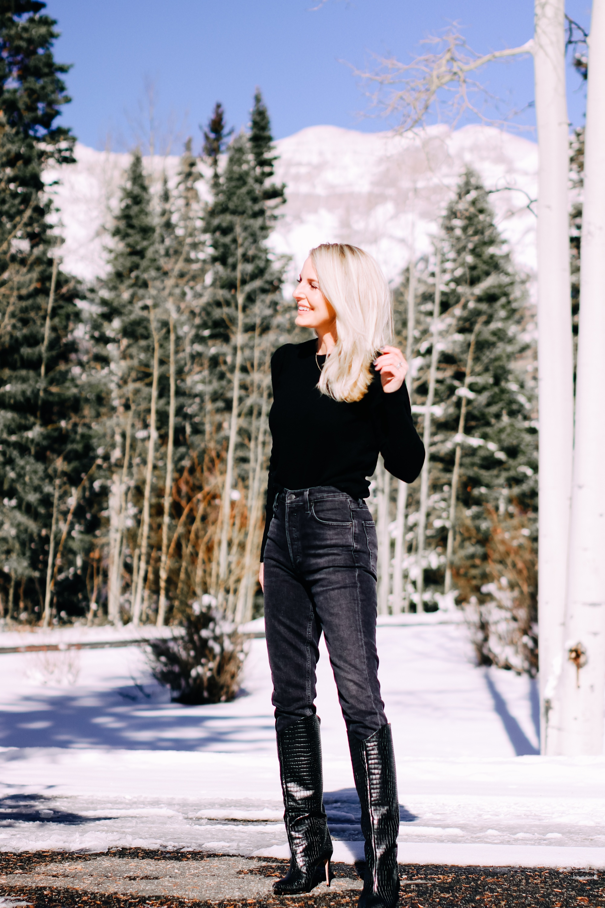 Thoughtful Gifts, Erin Busbee of Busbee Style wearing a black puff sleeve cashmere sweater by AQUA, gray wash Agolde jeans, black Sorel boots, and a diamond star necklace by Marc & Marcella from Bloomingdale's in Telluride, Colorado