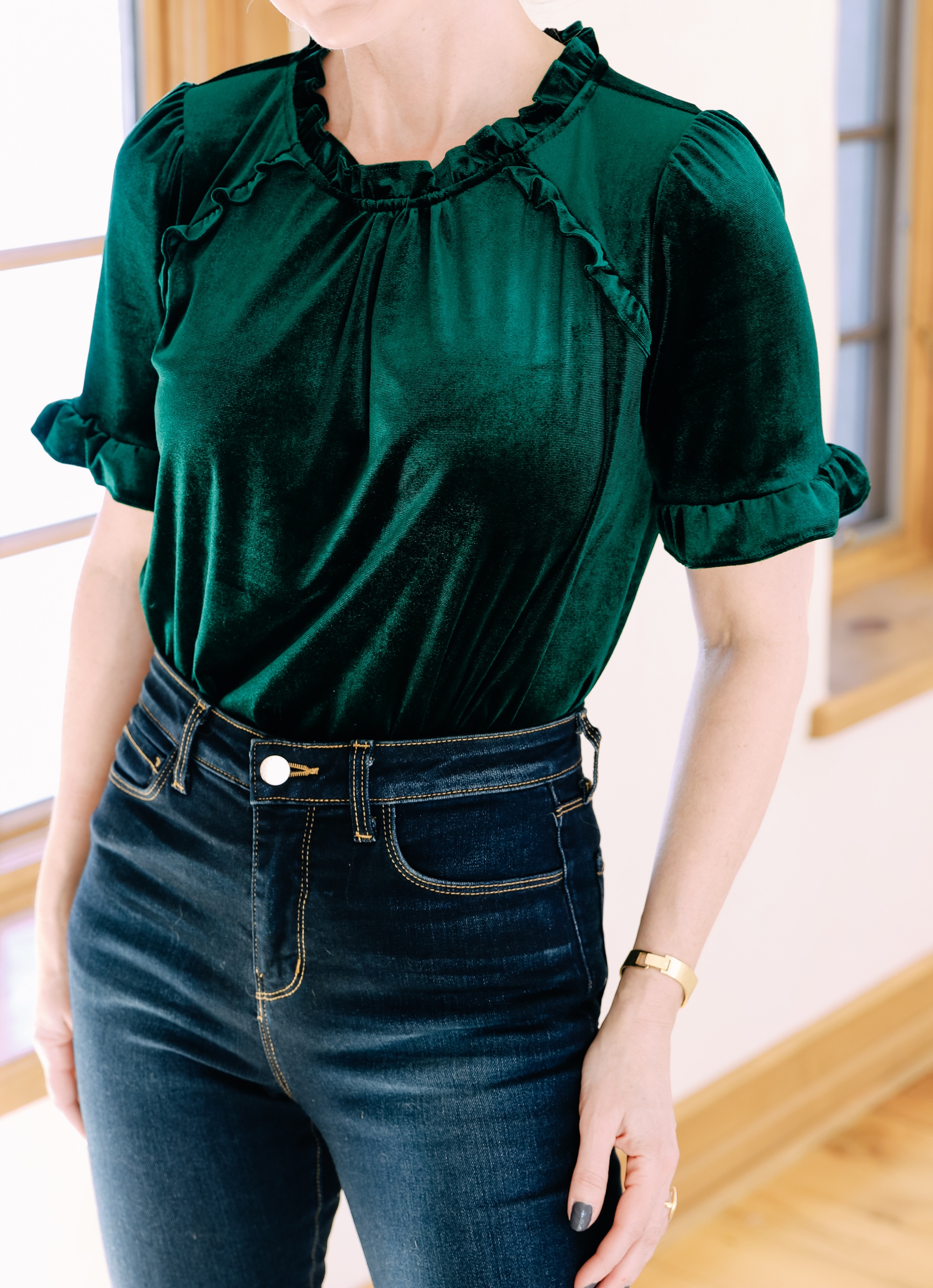 Holiday Outfits With Jeans, Erin Busbee of Busbee Style wearing a green velvet ruffle sleeve blouse by Gibson, L'Agence dark wash skinny jeans, and black Jimmy Choo Romy pumps from Nordstrom in Telluride, Colorado