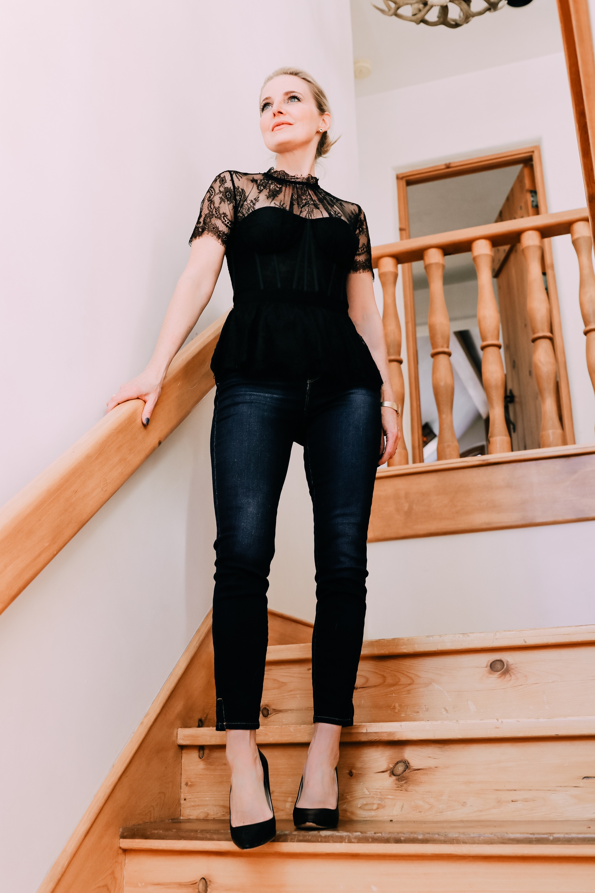 Holiday Outfits With Jeans, Erin Busbee of Busbee Style wearing a black lace corset top by Jonathan Simkhai, L'Agence dark wash skinny jeans, and black Jimmy Choo Romy pumps from Nordstrom in Telluride, Colorado