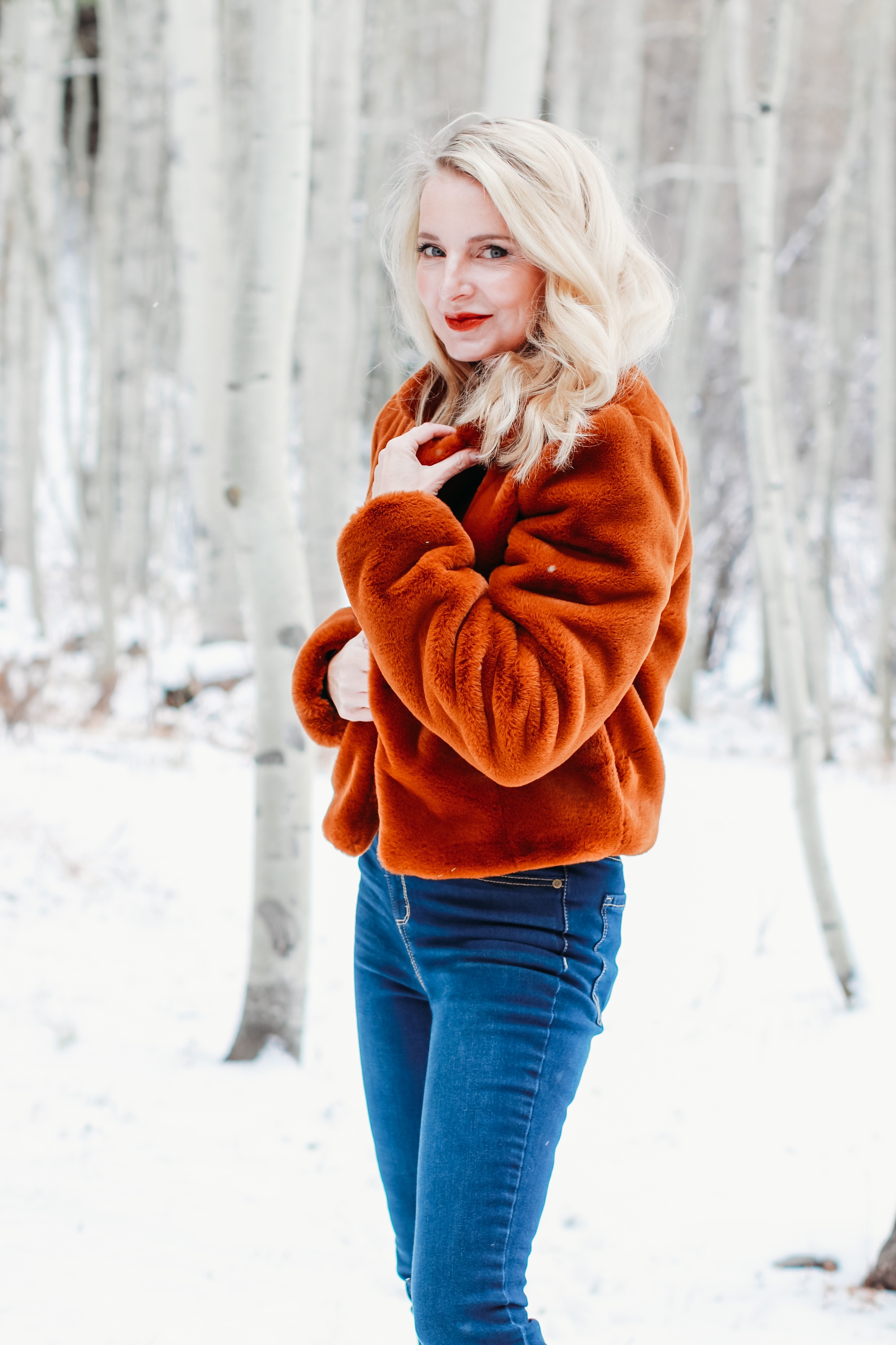 How to Wear Faux fur coat, Erin Busbee of Busbee Style wearing a brwon Blank NYC faux fur jacket with ribbed ruched sleeve sweater and dark wash skinny jeans from Express and Mou woven snow boots standing in the snow in Telluride, Colorado