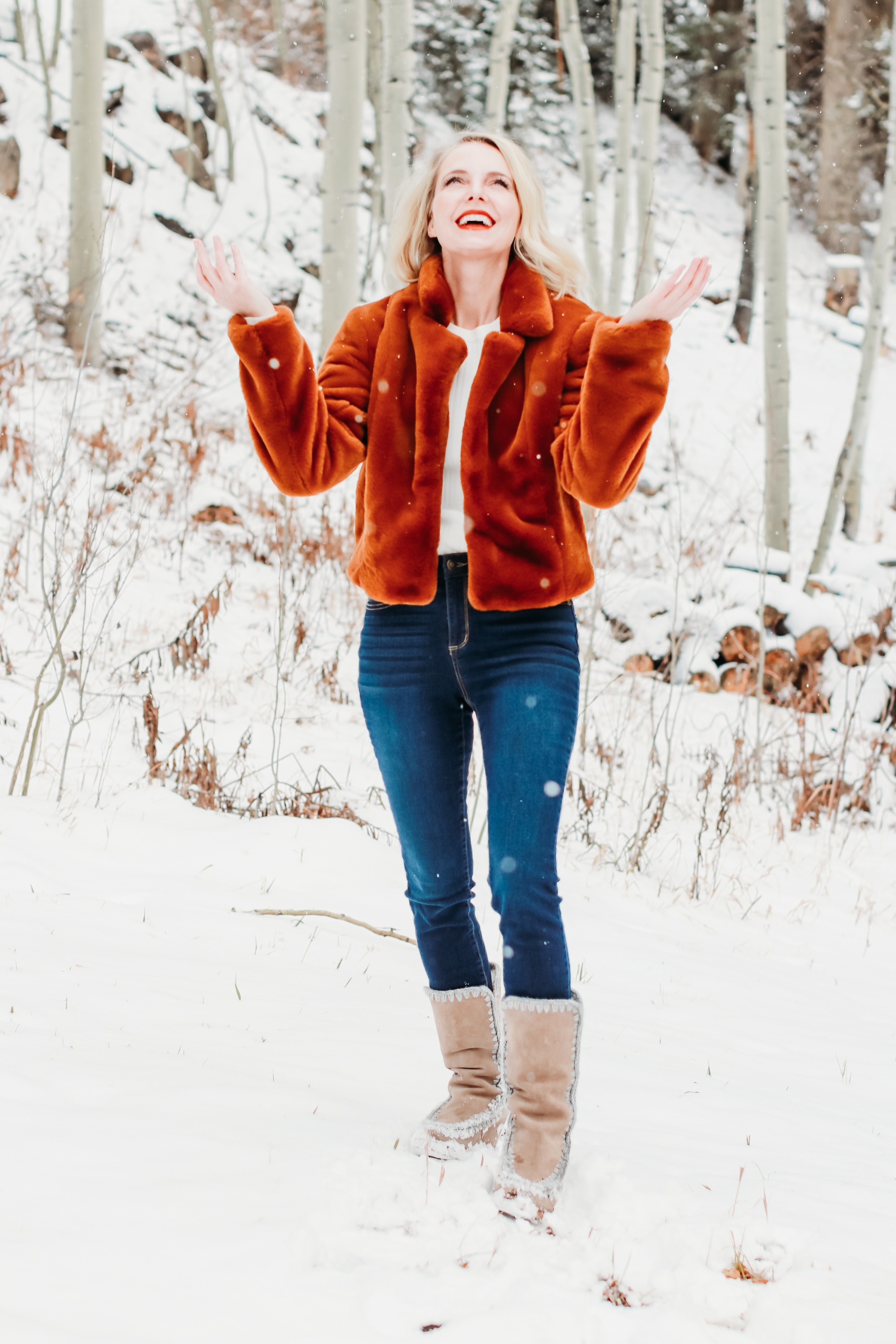 How to Wear Faux fur coat, Erin Busbee of Busbee Style wearing a brwon Blank NYC faux fur jacket with ribbed ruched sleeve sweater and dark wash skinny jeans from Express and Mou woven snow boots standing in the snow in Telluride, Colorado