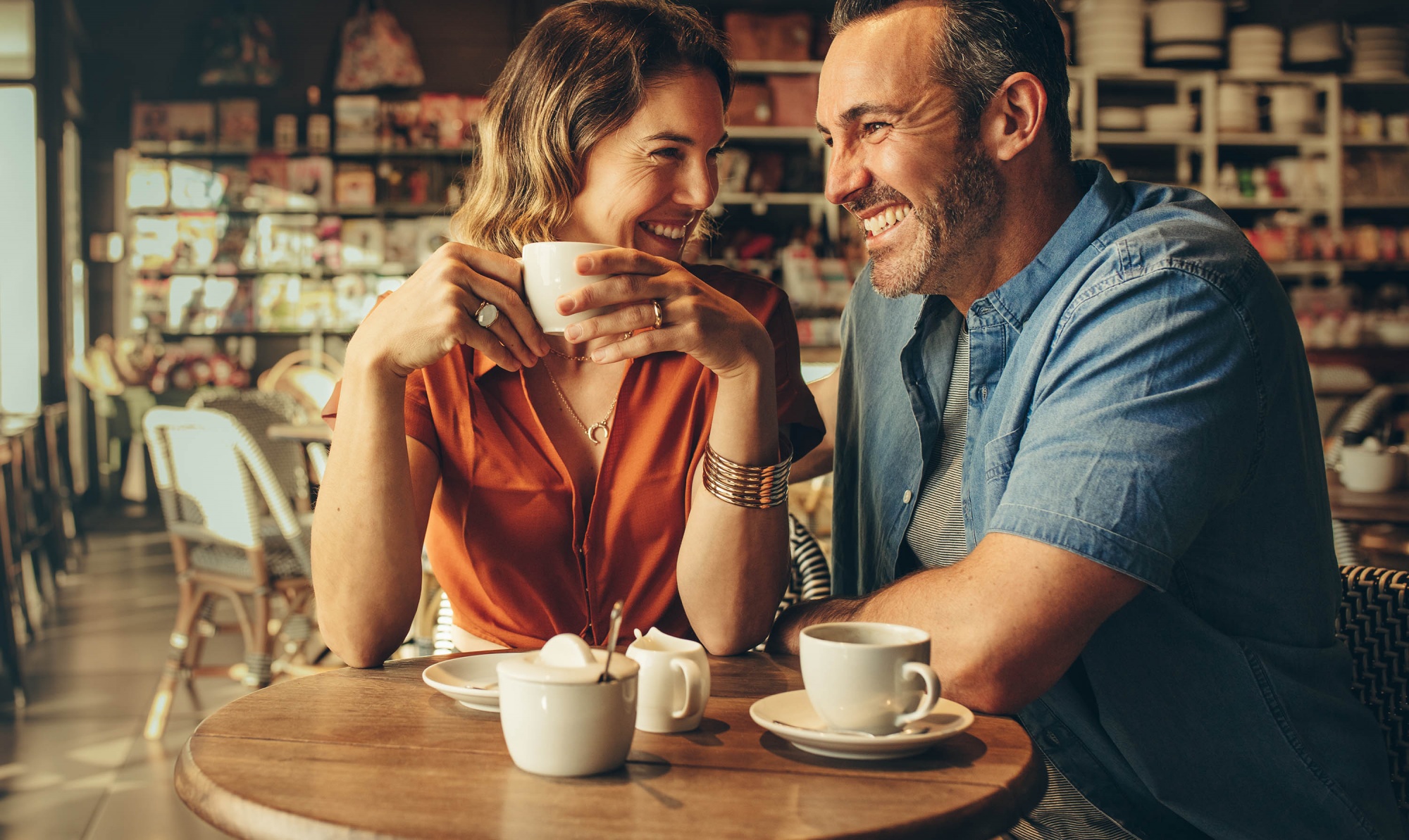 dating over 40, happy couple having coffee in a café and laughing
