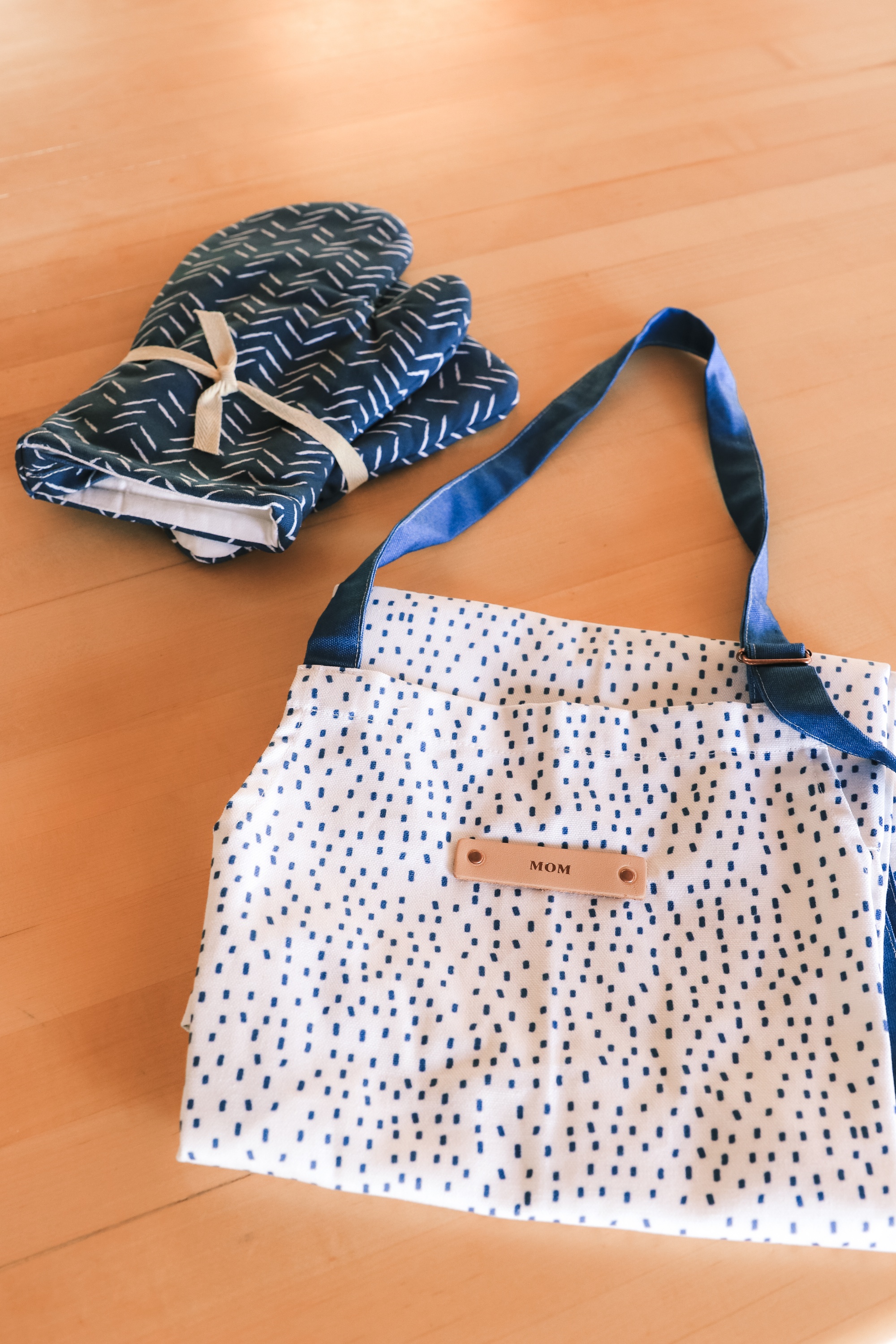 Personalized Gifts, Erin Busbee of Busbee Style sharing a blue herringbone mitt and potholder set and blue and white speckled apron with "mom" from Minted in Telluride, Colorado