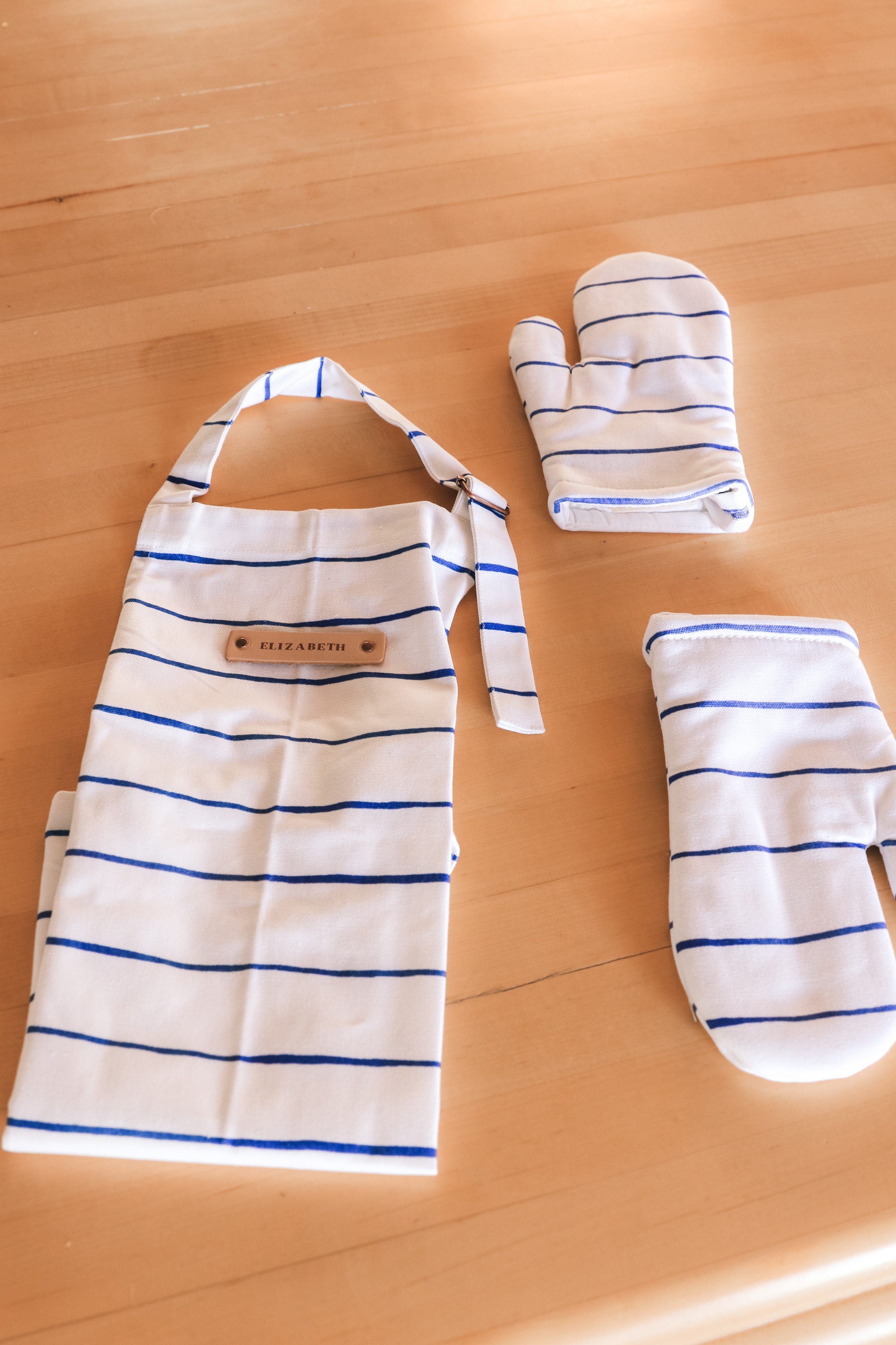 Personalized Gifts, Erin Busbee of Busbee Style sharing a blue and white striped apron with "Elizabeth" on it for her daughter and matching blue and white striped oven mitts from Minted for her daughter in Telluride, Colorado