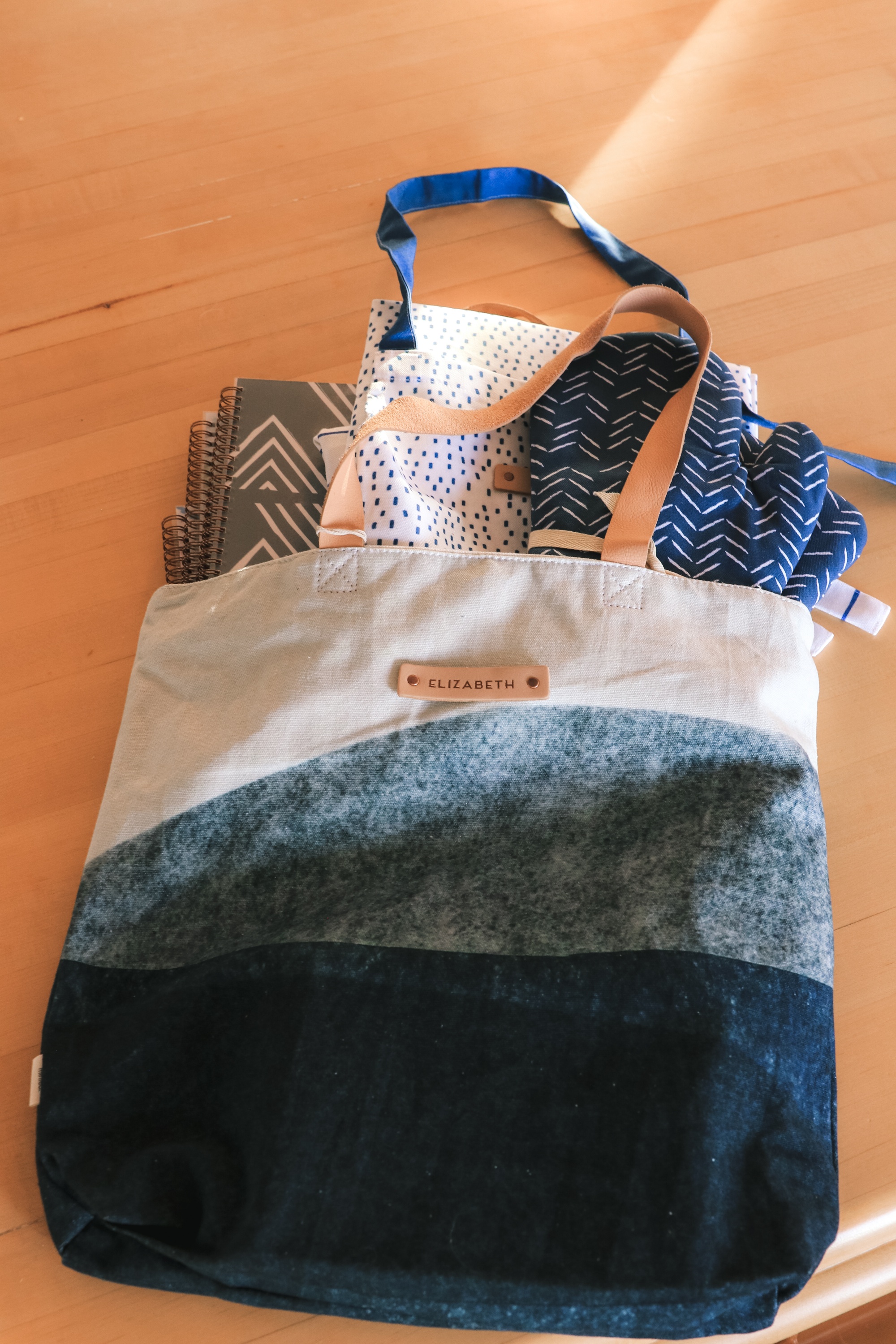 Personalized Gifts, Erin Busbee of Busbee Style sharing a blue and white personalized tote bag with three personalized planners, oven mitts, and aprons from Minted in Telluride, Colorado