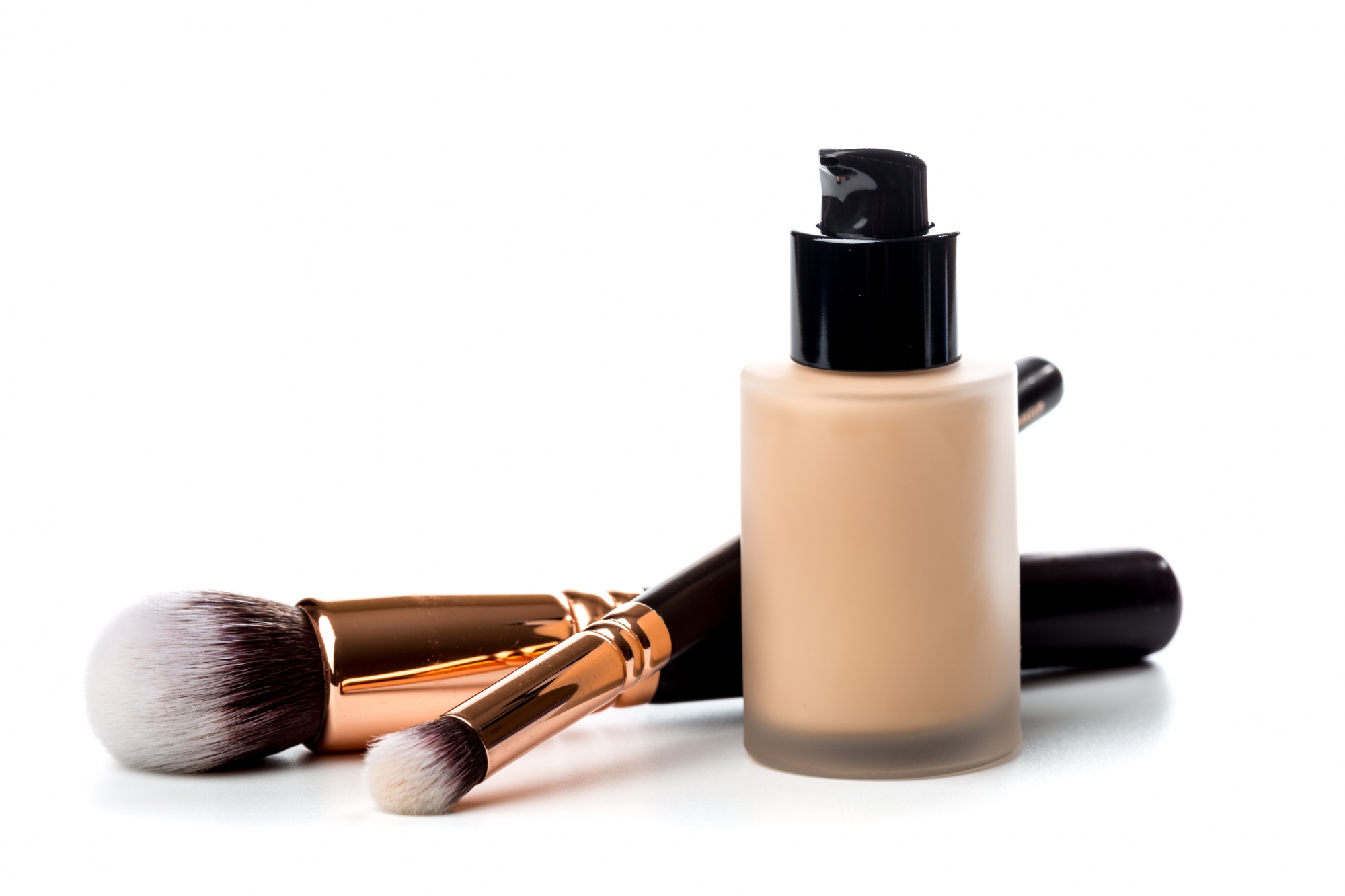 Finding the best foundation for you Close-up of flat makeup brush with liquid foundation tube isolated on white