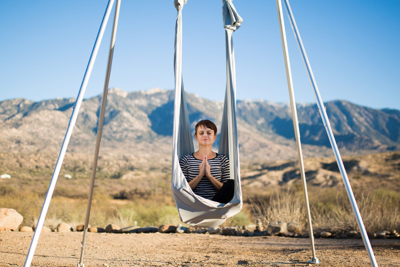 fun girls getaways, woman peacefully meditating in a silk hammock at Miraval Resort in Tucson, Arizona