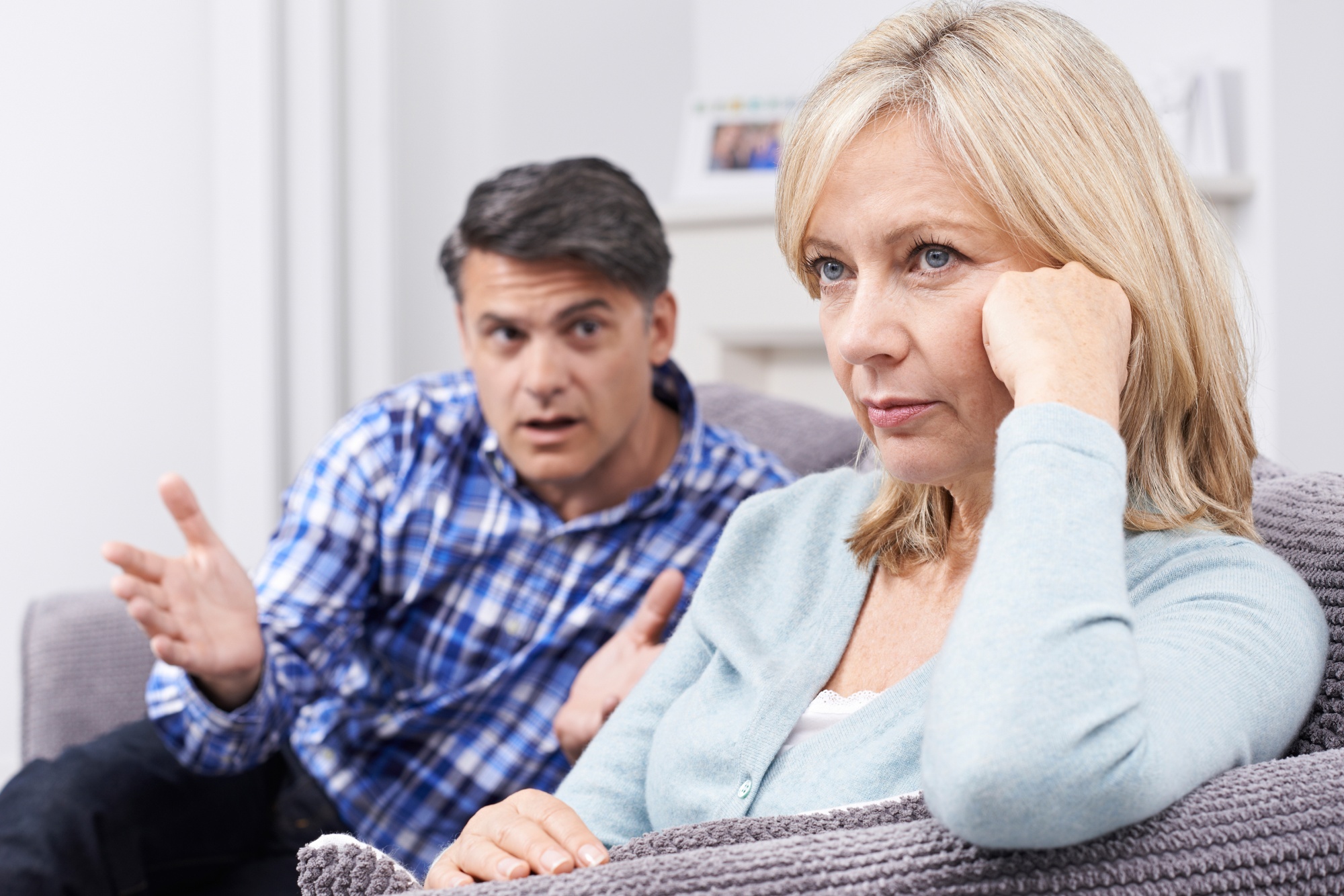 Toxic relationship habits, husband trying to talk to wife who is looking sad and ignoring him