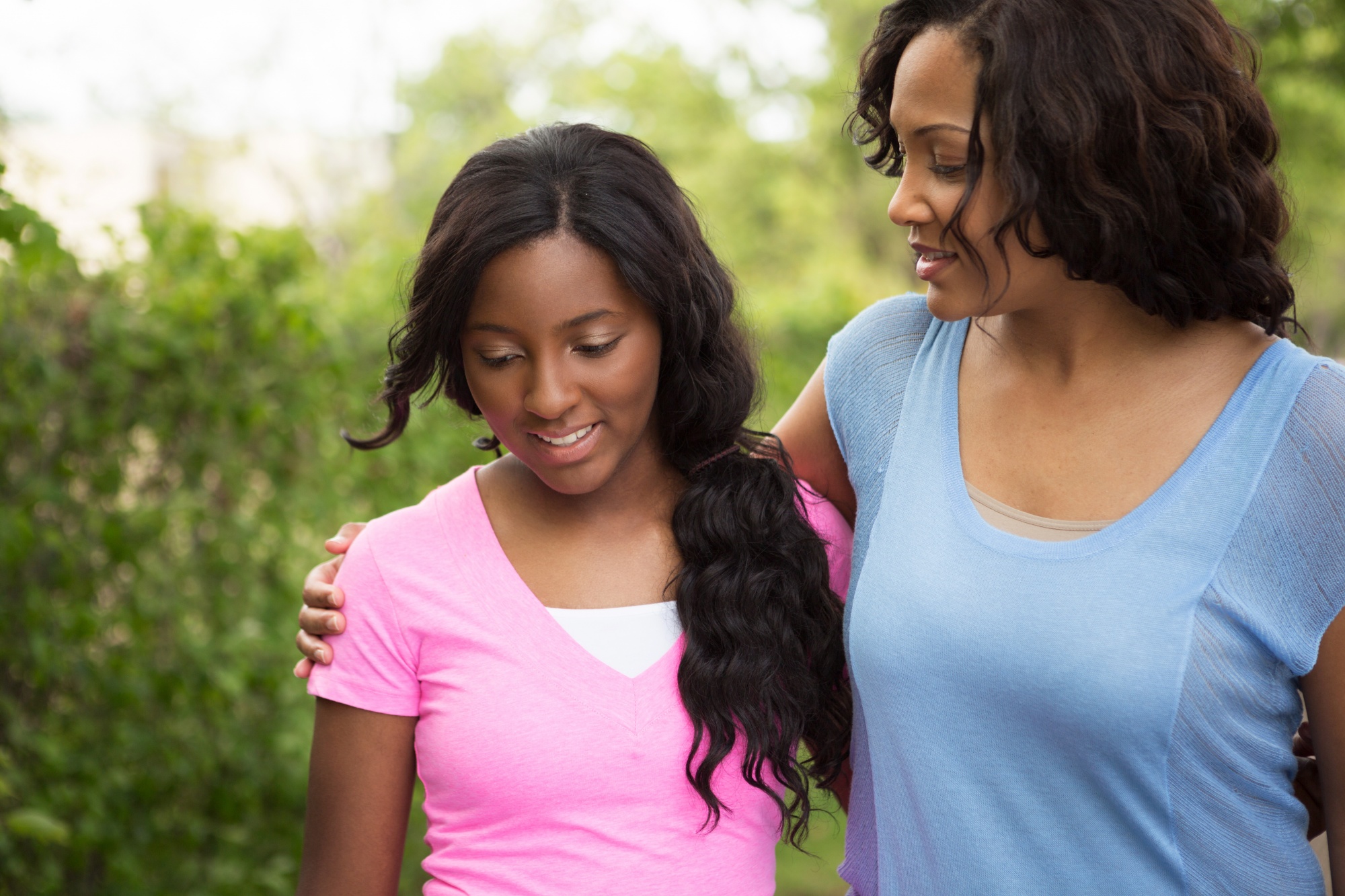 talking about sex, African-American mother and daughter walking outside together and smiling