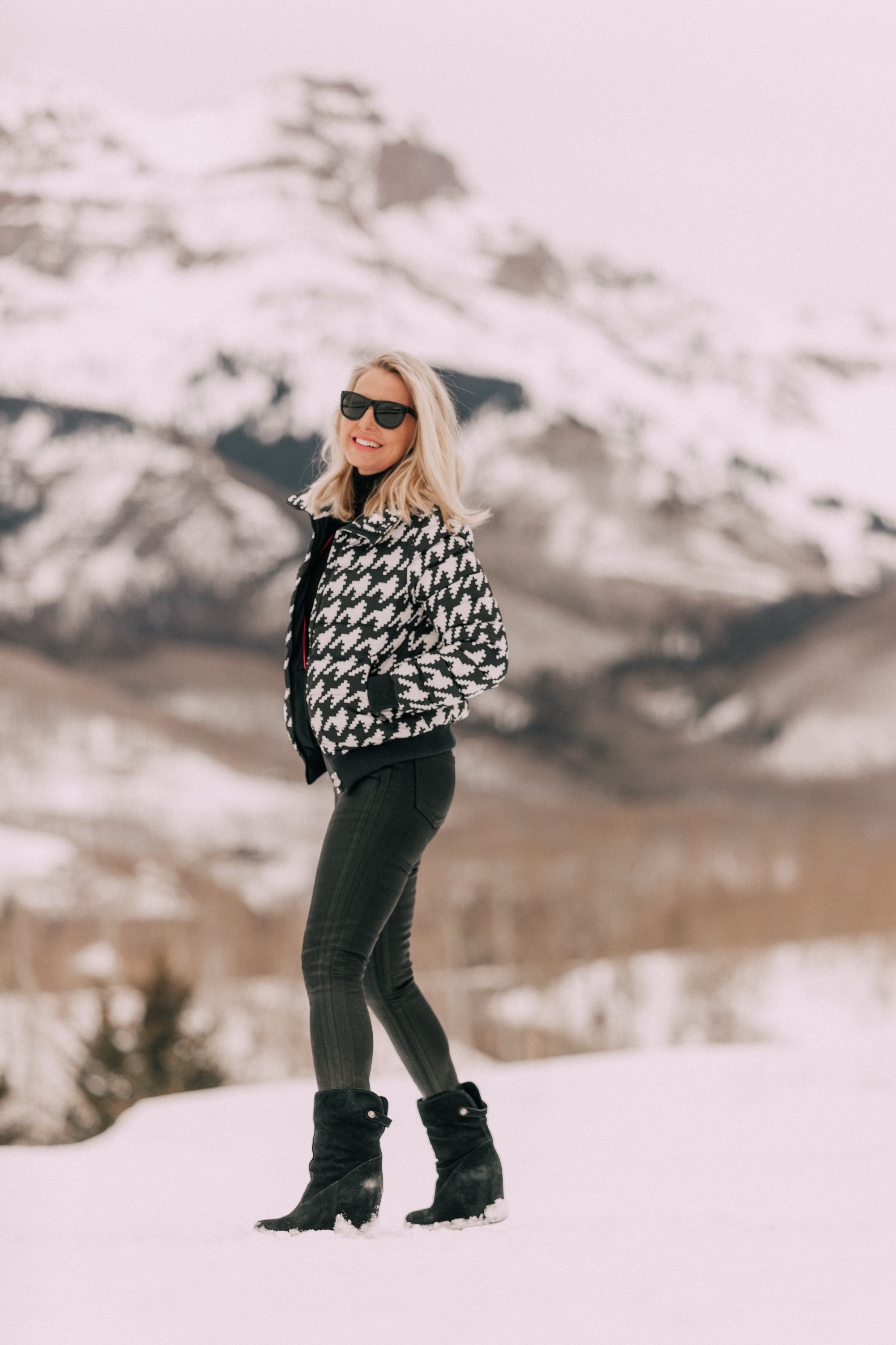 A houndstooth print puffer jacket by Perfect Moment on fashion over 40 blogger Erin Busbee of Busbee Style in snowy mountains of Telluride, Colorado