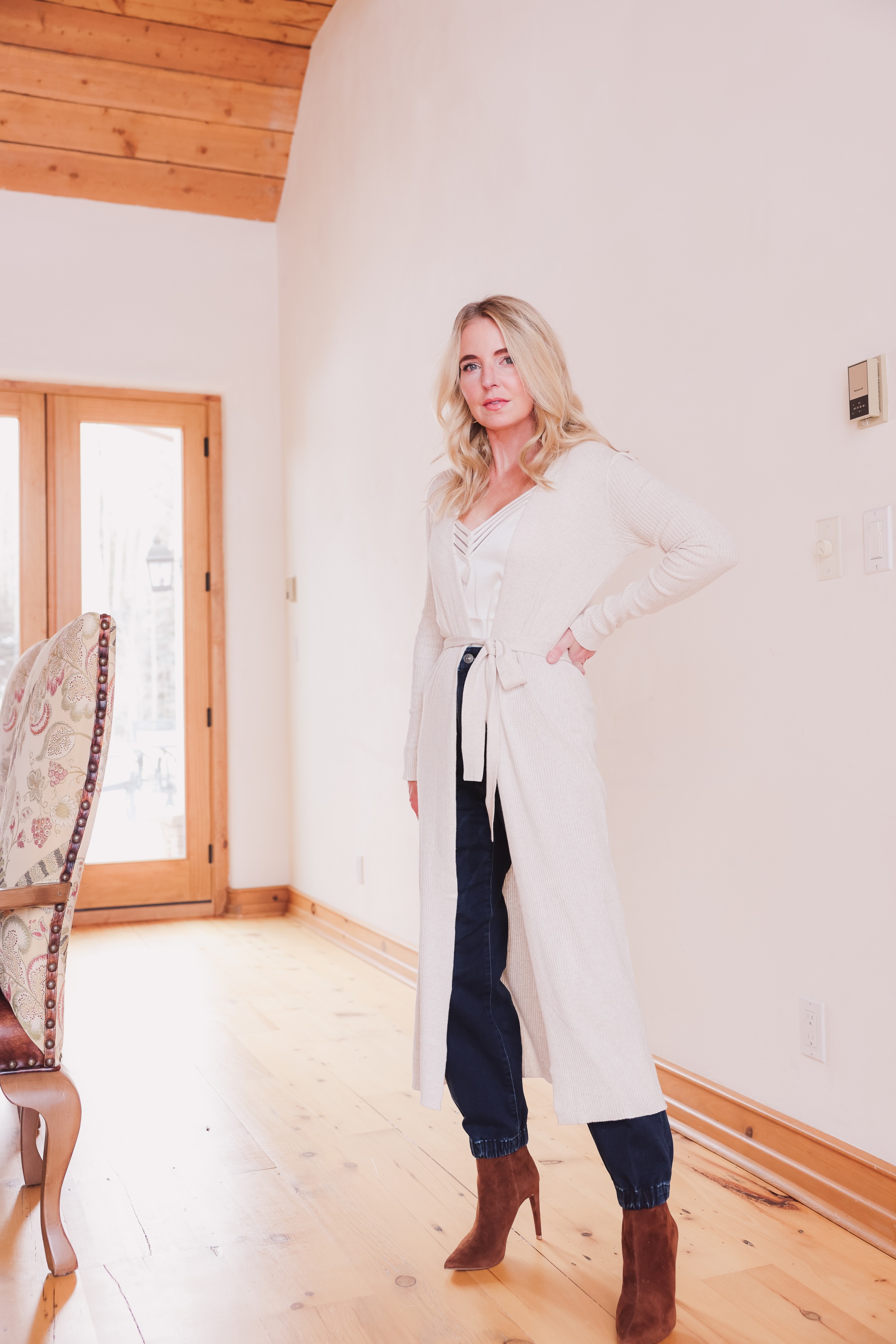 Express Sale, Erin Busbee of Busbee wearing denim joggers, a white satin cami, and long ribbed duster cardigan from Express with Steve Madden brown booties in Telluride, Colorado