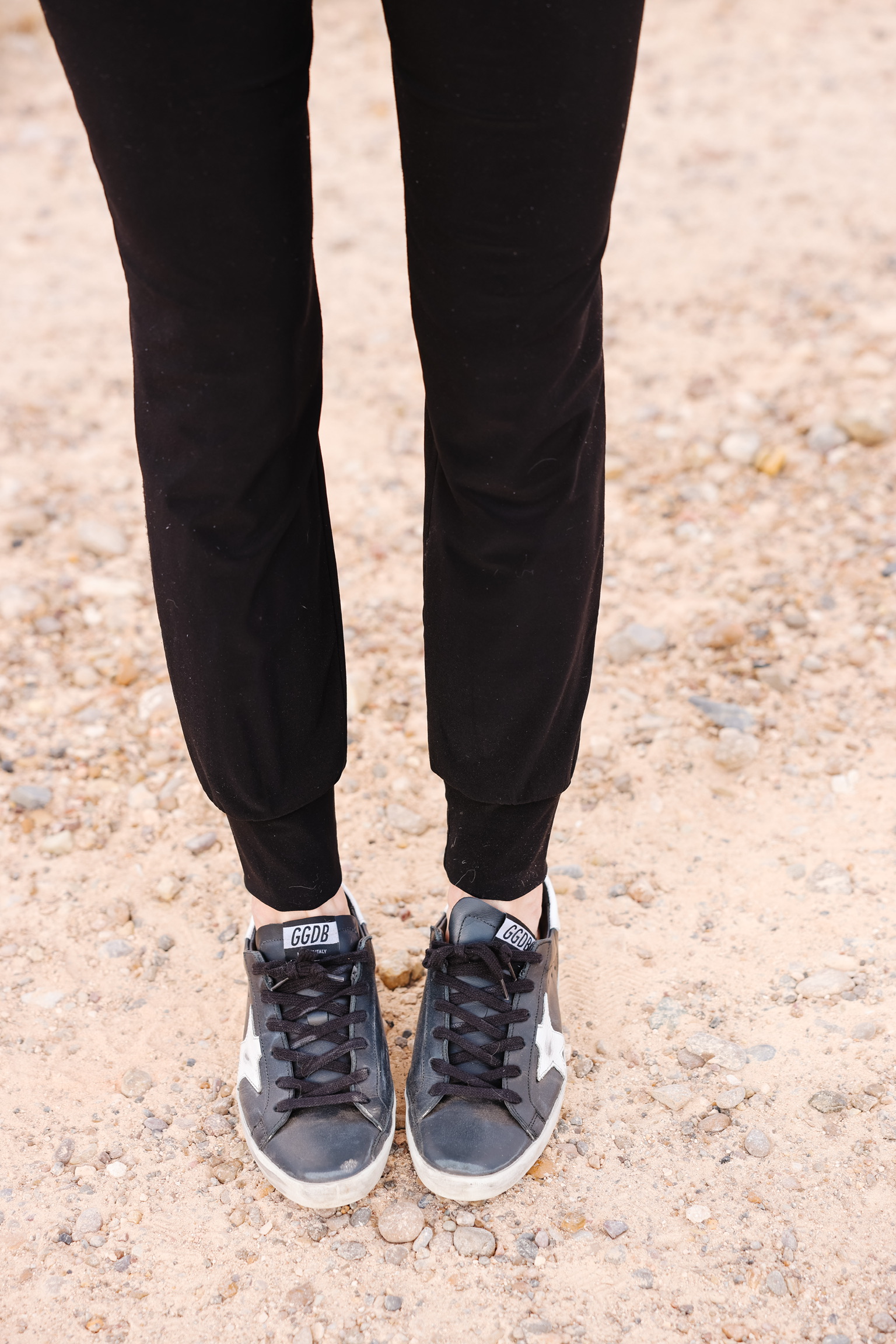 Elevated Basics, Erin Busbee of Busbee wearing black golden goose sneakers with black joggers by Norma Kamali in south texas, what shoes to wear with jeans