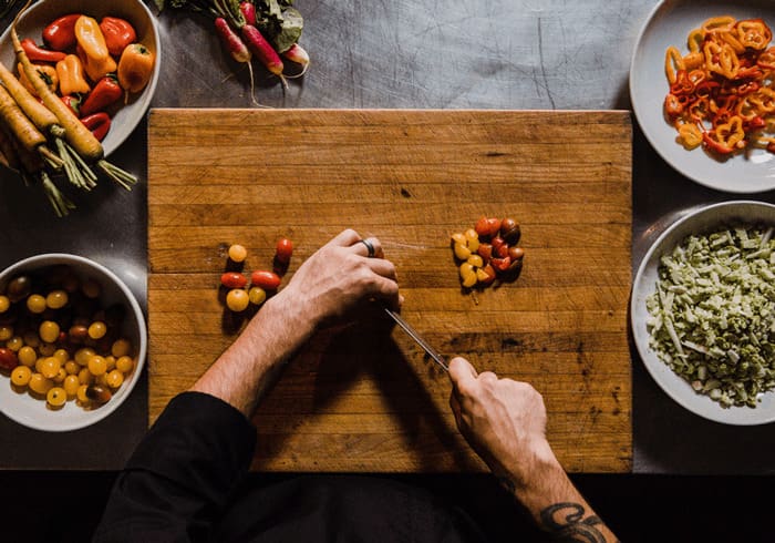 best meal delivery services, hands chopping vegetables on a large cutting board