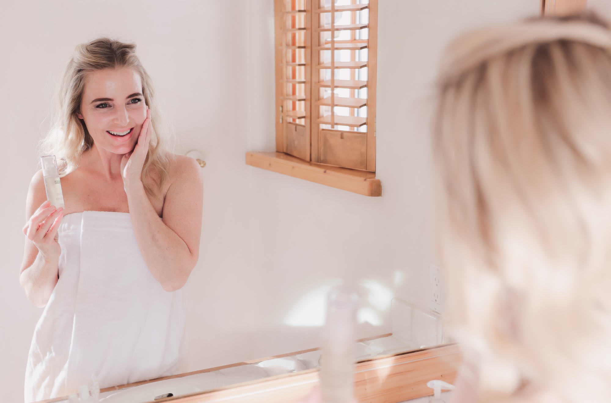 Best Skincare Over 40, Erin Busbee of Busbee using the Colleen Rothschild Mandelic Acid Radiance Serum in her bathroom in Telluride, Colorado