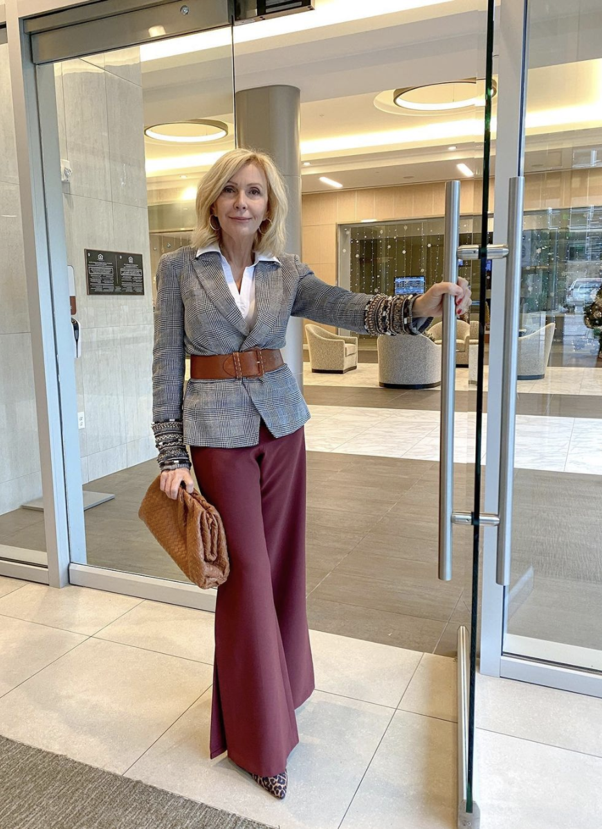 Styling Blazers Over 40, Sonia of Style Beyond Age wearing a belted plaid blazer over a white button down and burgundy wide leg jeans