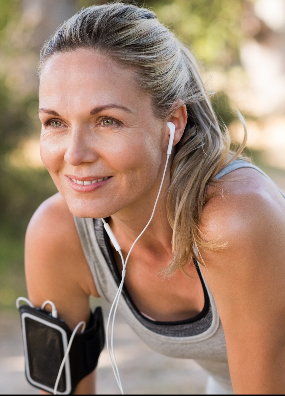 how to get fit over 40, blonde woman in grey tank post run with earbuds and armband