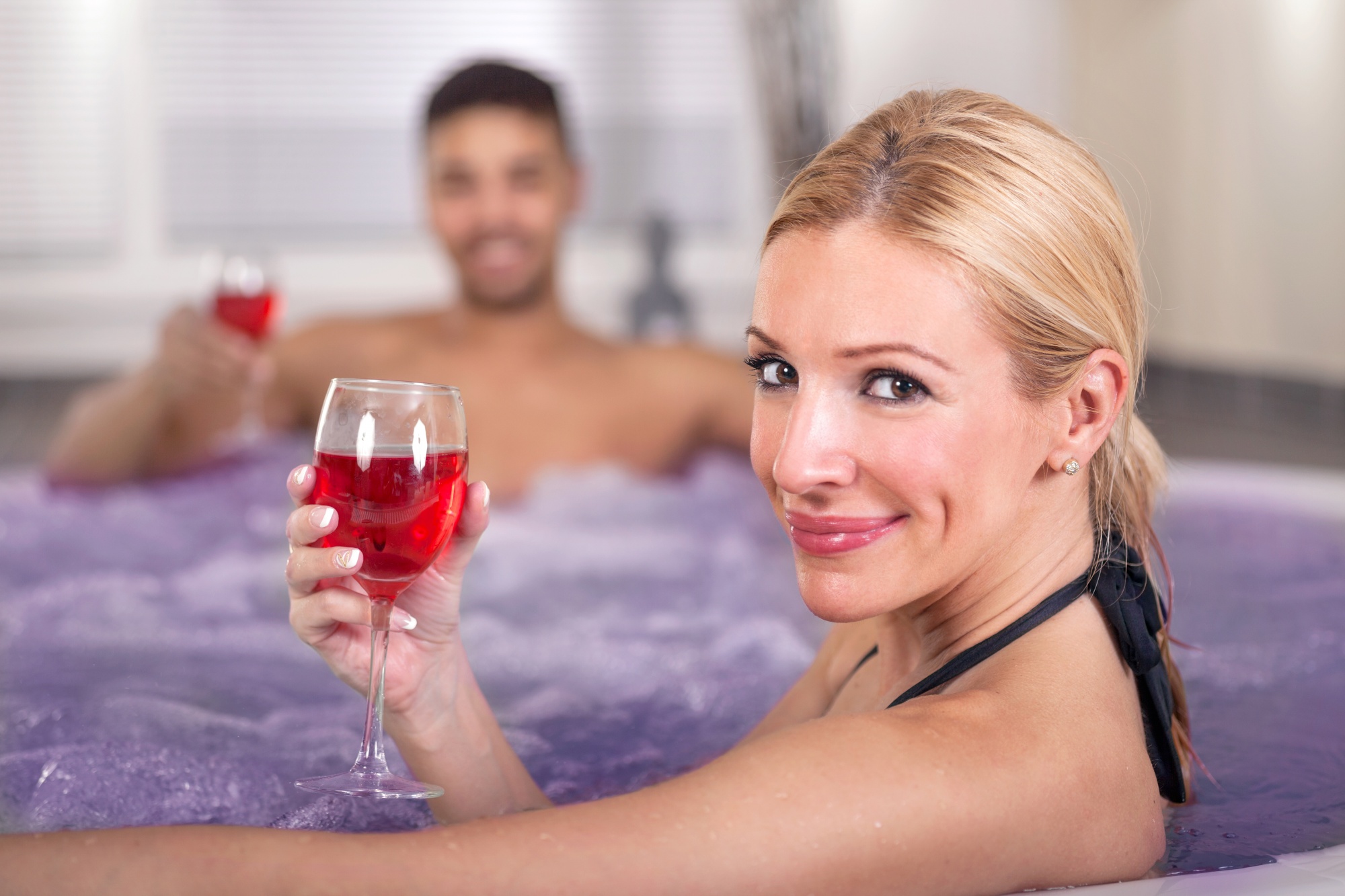 Let's Talk About Sex: When Being Too Busy Interferes With "Getting Busy". Blonde woman drinking red wine with man in hot tub