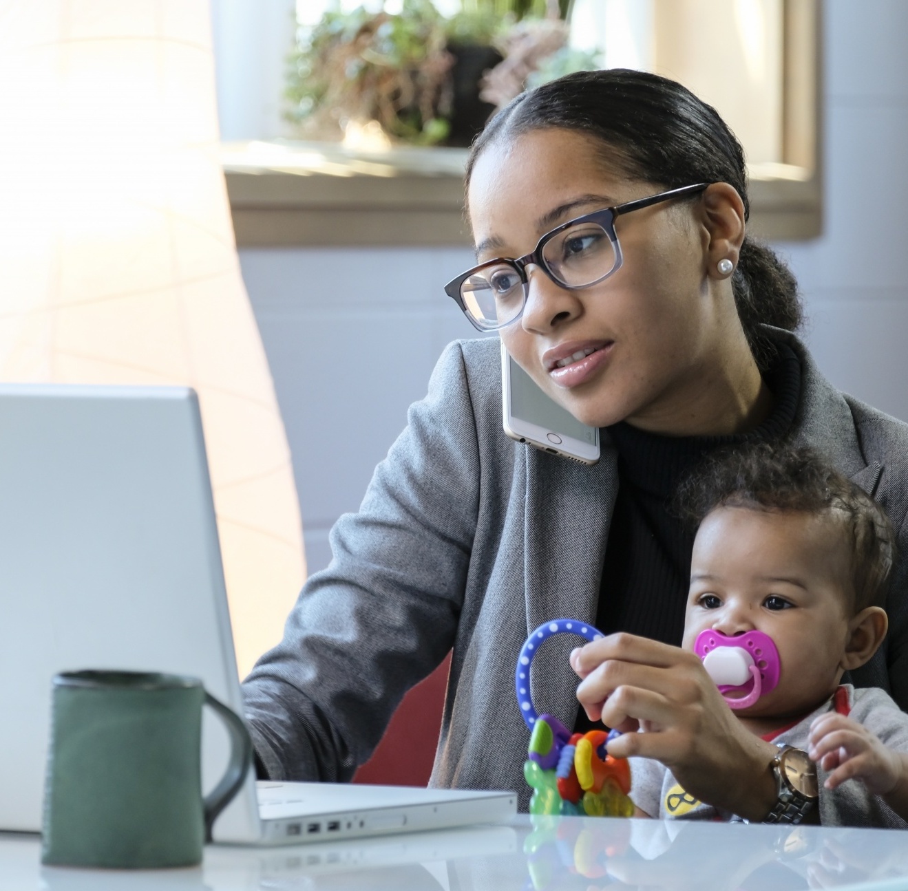 Let's Talk About Sex: When Being Too Busy Interferes With "Getting Busy". African American woman working on laptop at home with baby on her lap