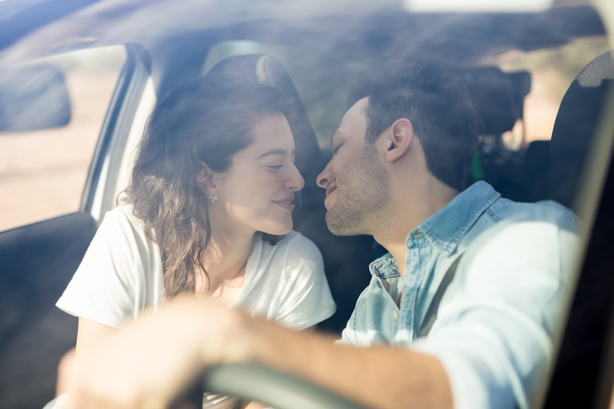 Let's Talk About Sex: When Being Too Busy Interferes With "Getting Busy" Woman and man leaning in to kiss each other in front seat of car