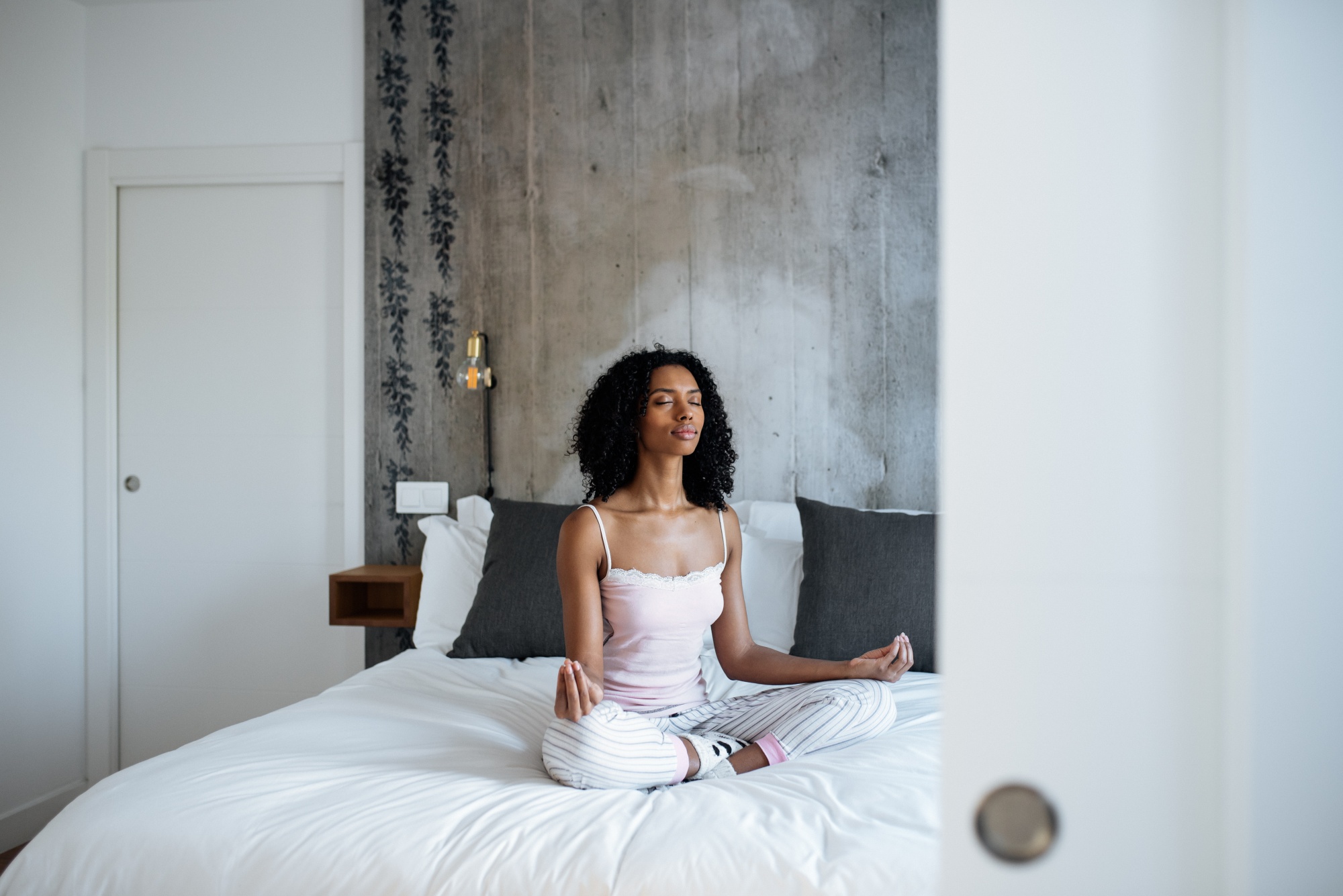 better sex after menopause, Attractive black woman sitting in lotus position on bed meditating