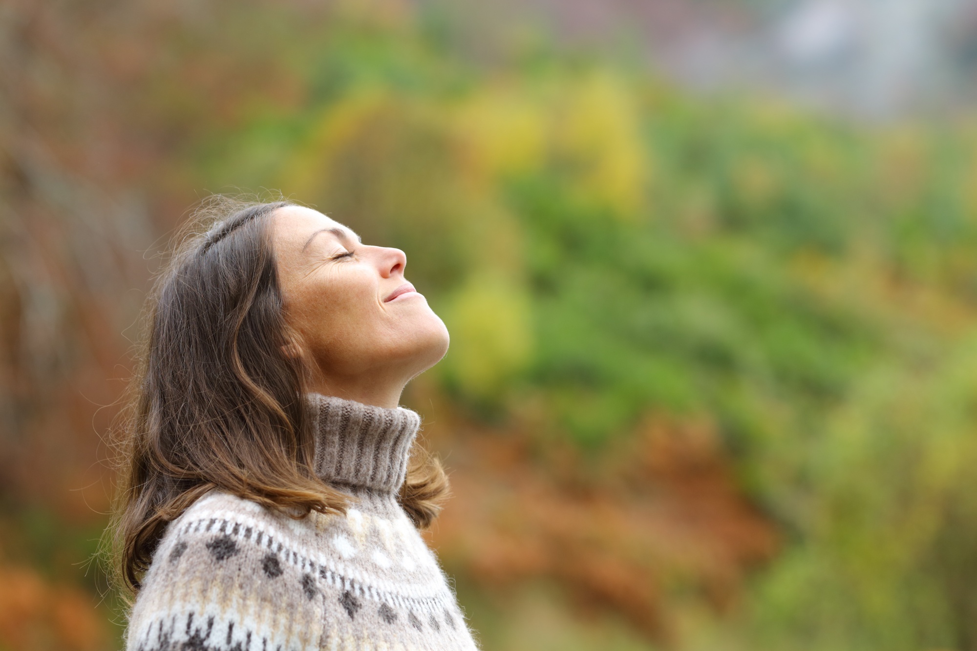 what is neuroplasticity? How to build your brain, Brunette woman in fair isle sweater in autumn face in sun meditating
