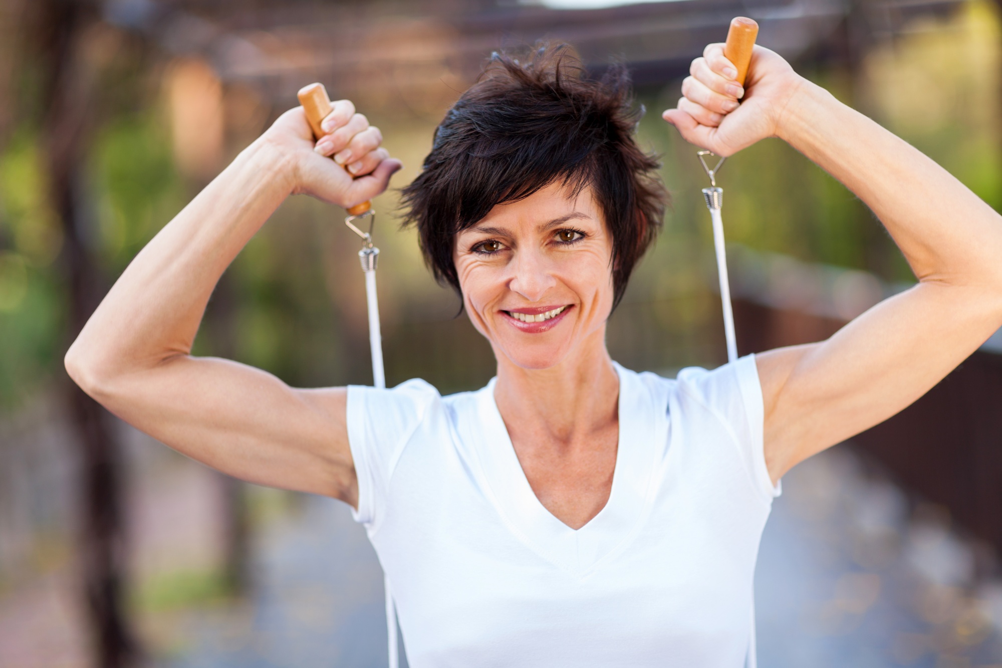 get rid of mummy tummy for good, Dark pixi-haired middle aged woman strong arms with jumping rope