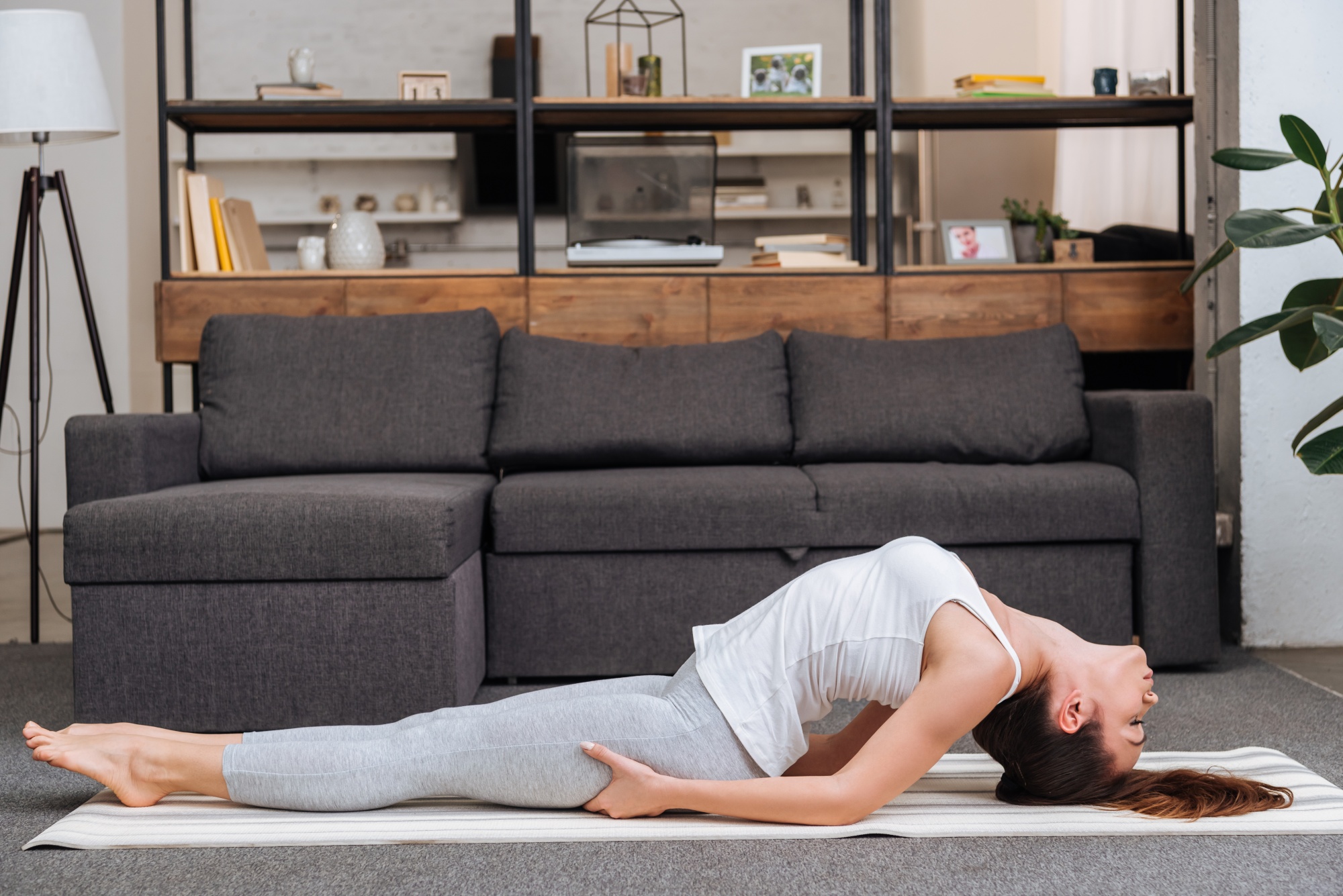 better sex after menopause, woman practicing fish pose at home in living room